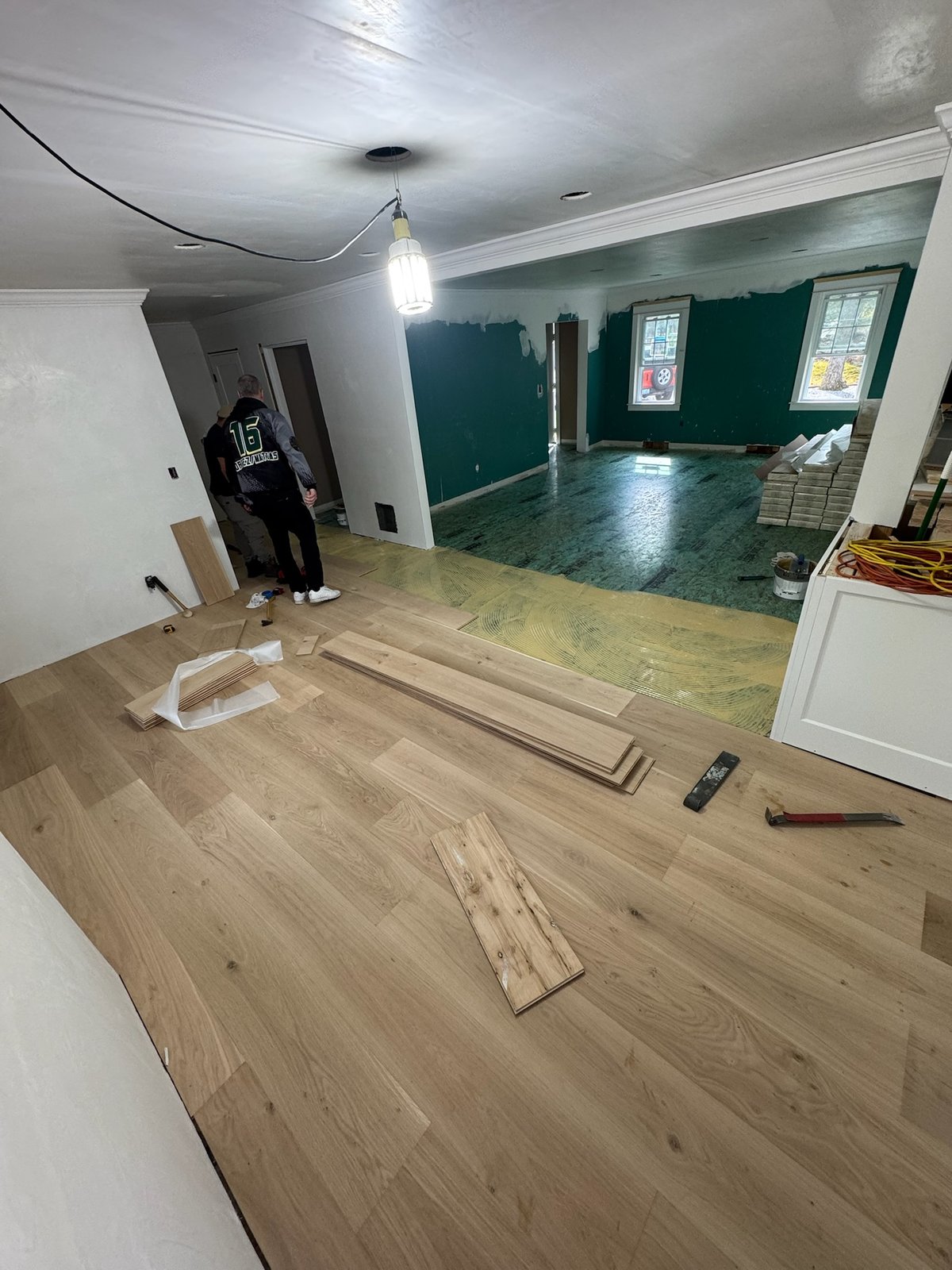 North Kingstown RI — wide-plank white oak seated into adhesive with trowel coverage ahead