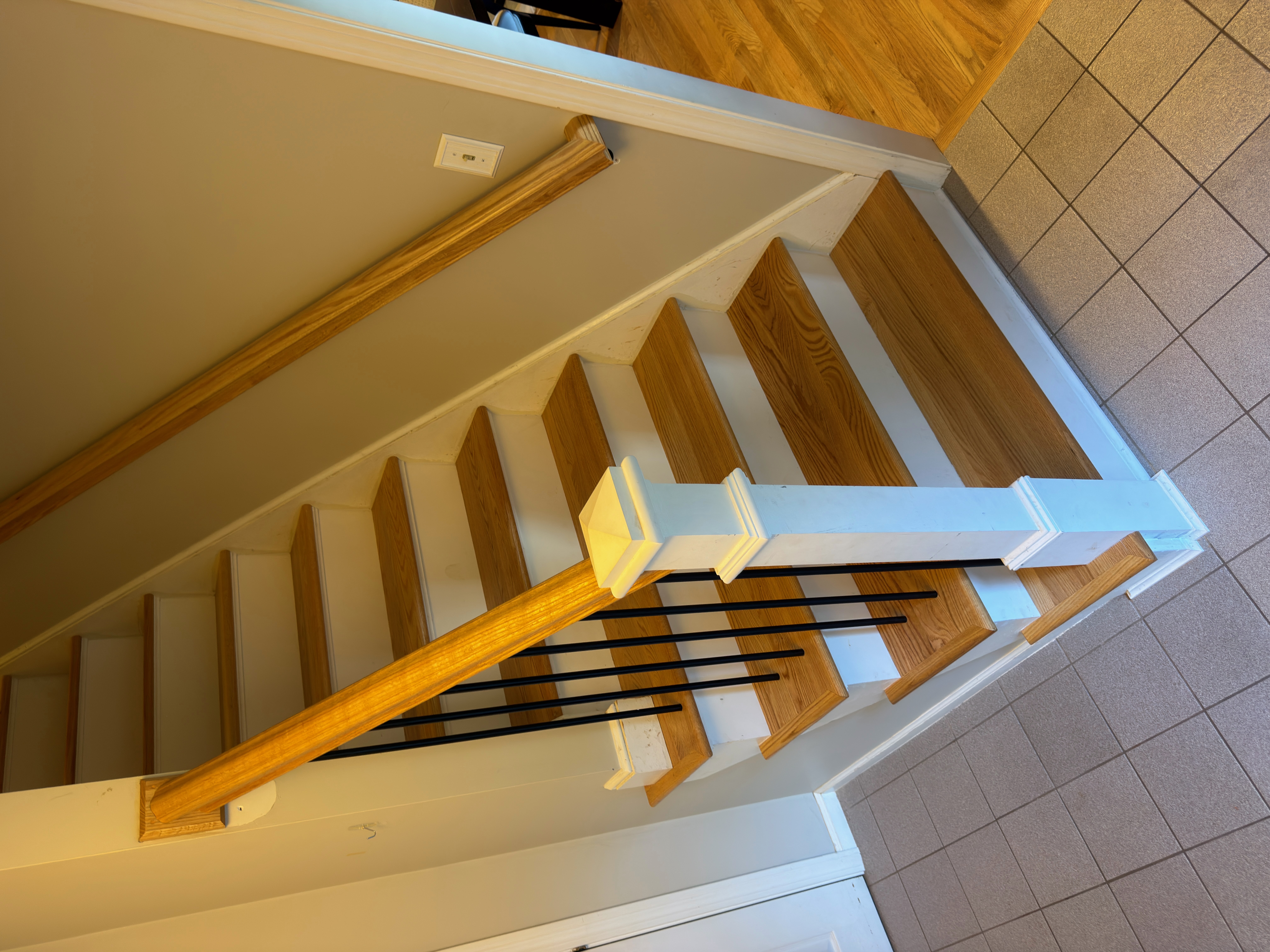 Wrentham MA — finished staircase from top looking down, new red oak treads and black metal balusters