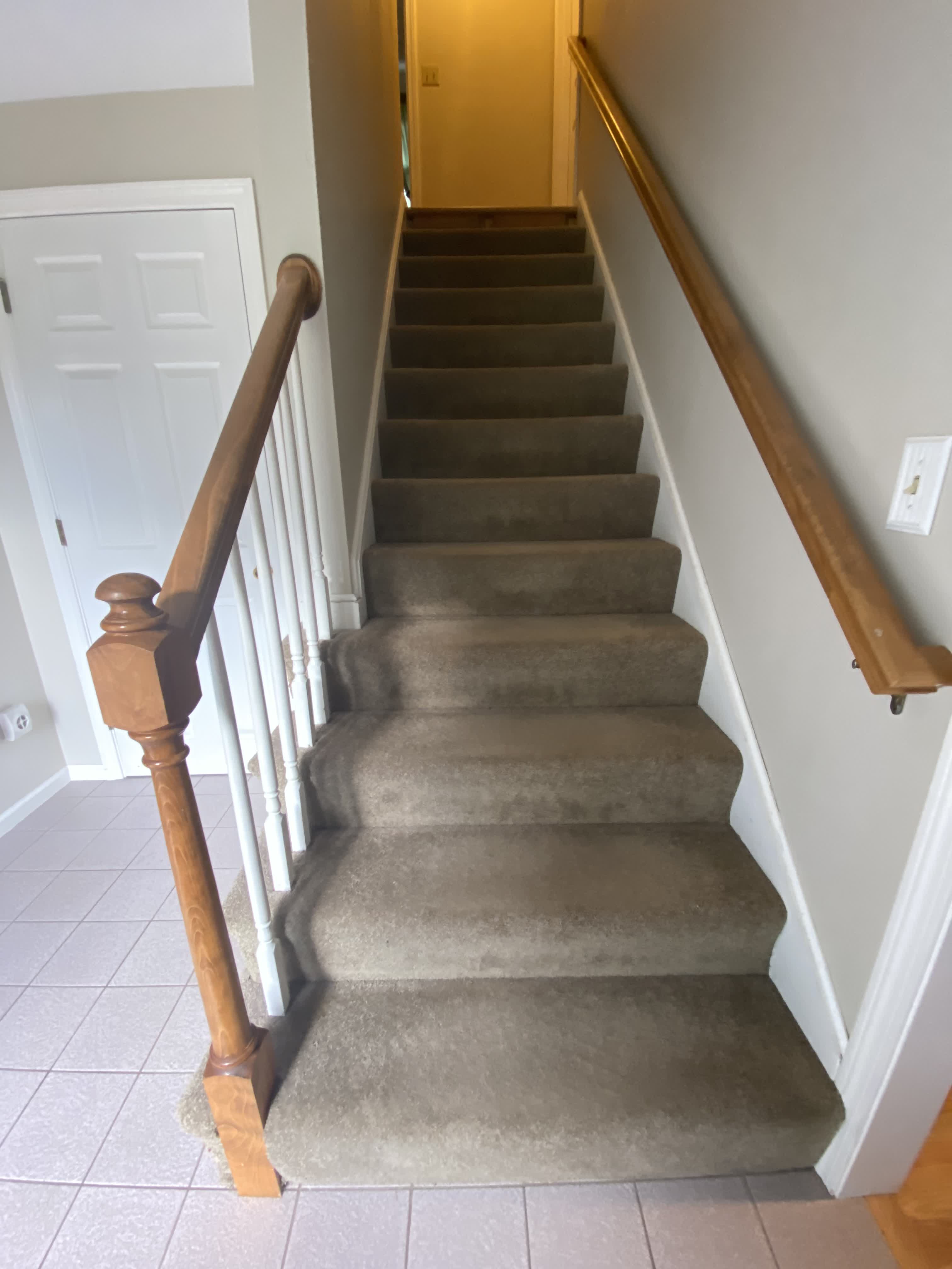 Wrentham MA — staircase before renovation, full view from bottom showing carpet treads and original turned newel post