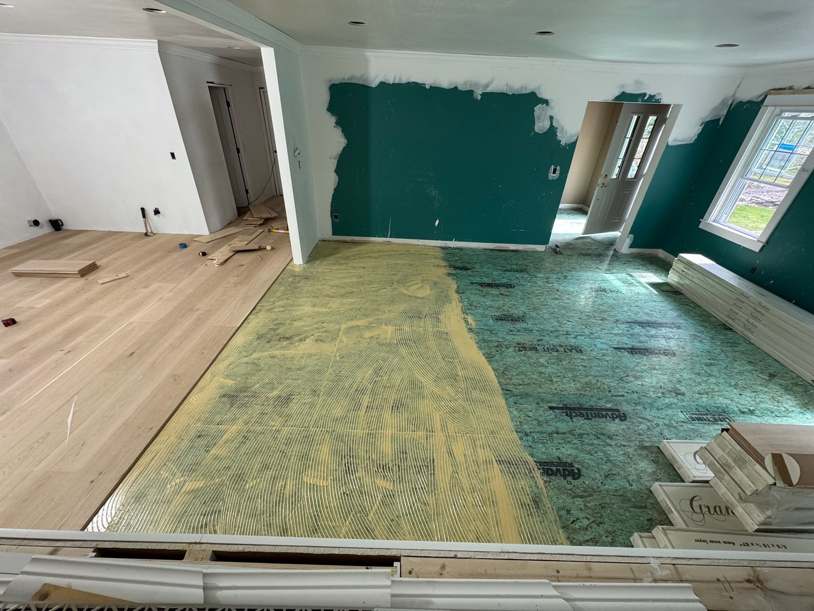 North Kingstown RI — wide-plank white oak planks set with adhesive spread ahead