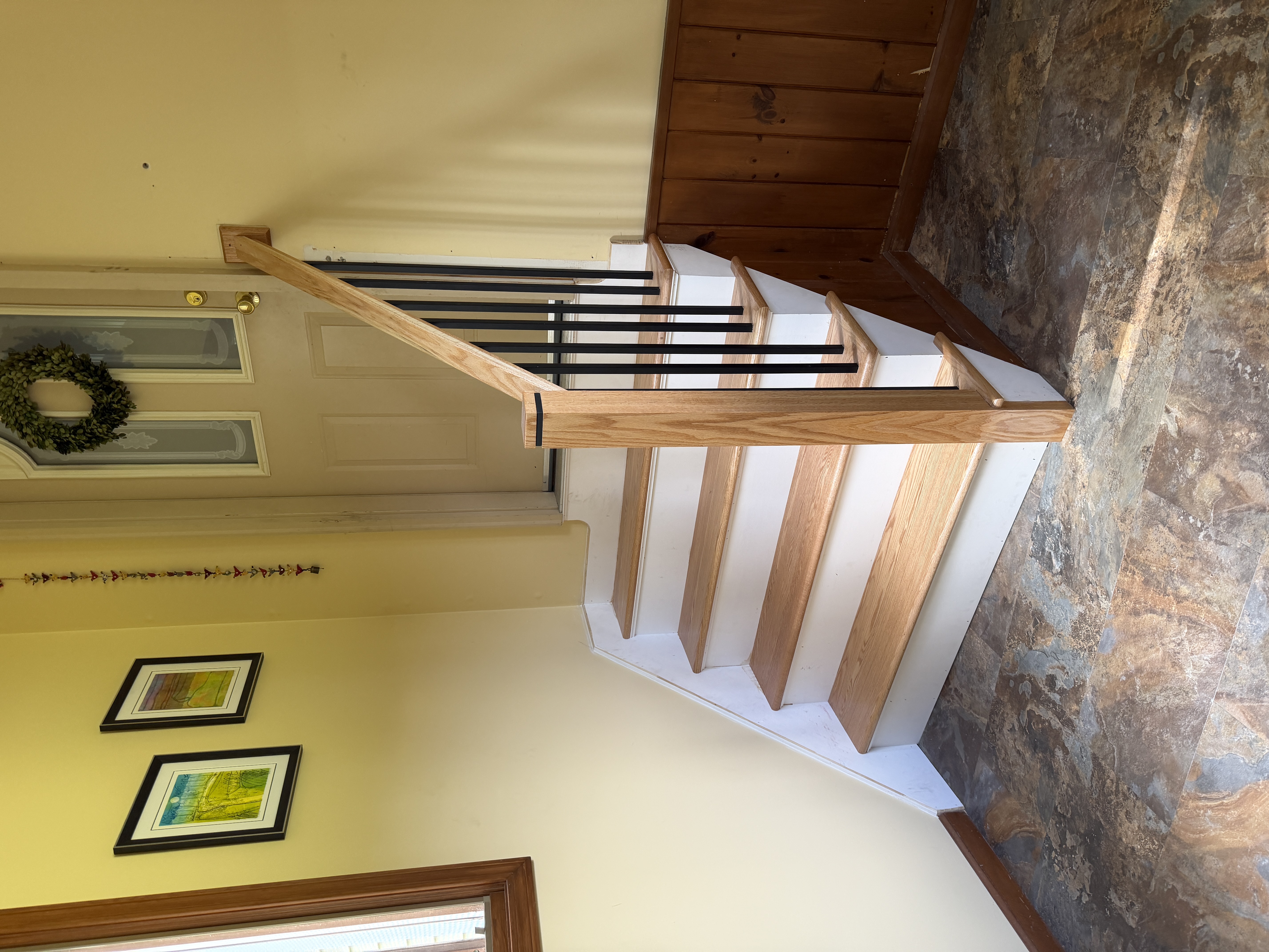 After custom staircase renovation — red oak treads, white risers, iron balusters, and oak handrail Rhode Island