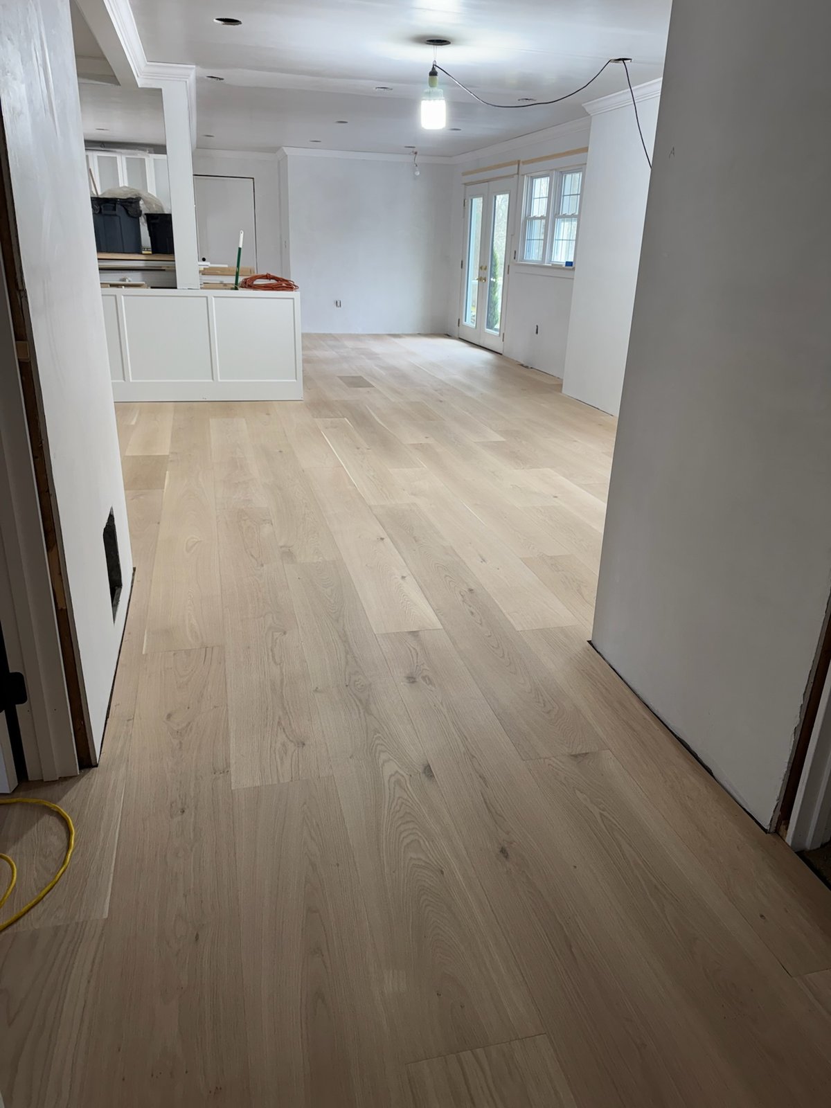 North Kingstown RI — raw installed wide-plank white oak floor before on-site finishing, angle one