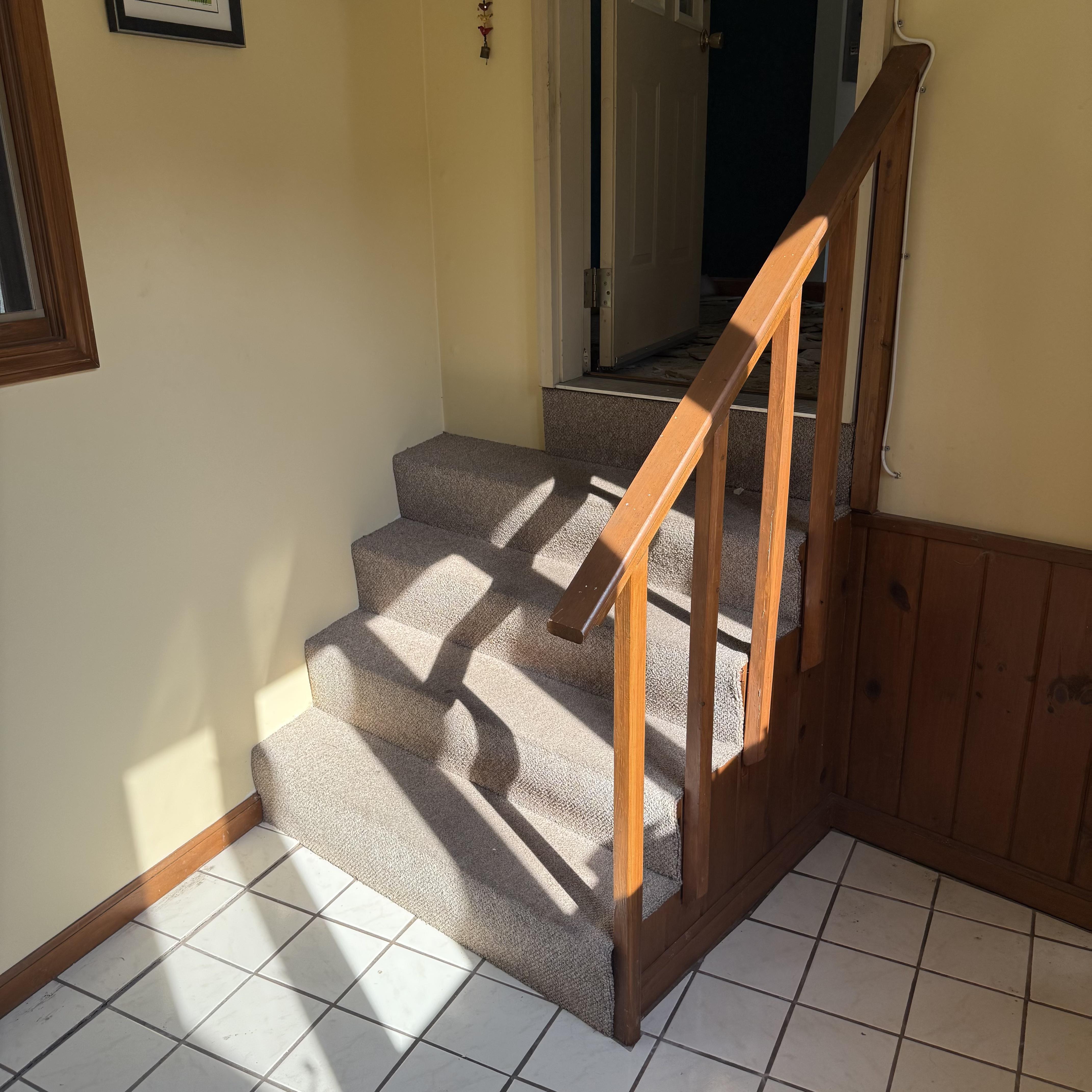 Before staircase renovation — carpeted stairs with old wooden railing and balusters, Rhode Island home