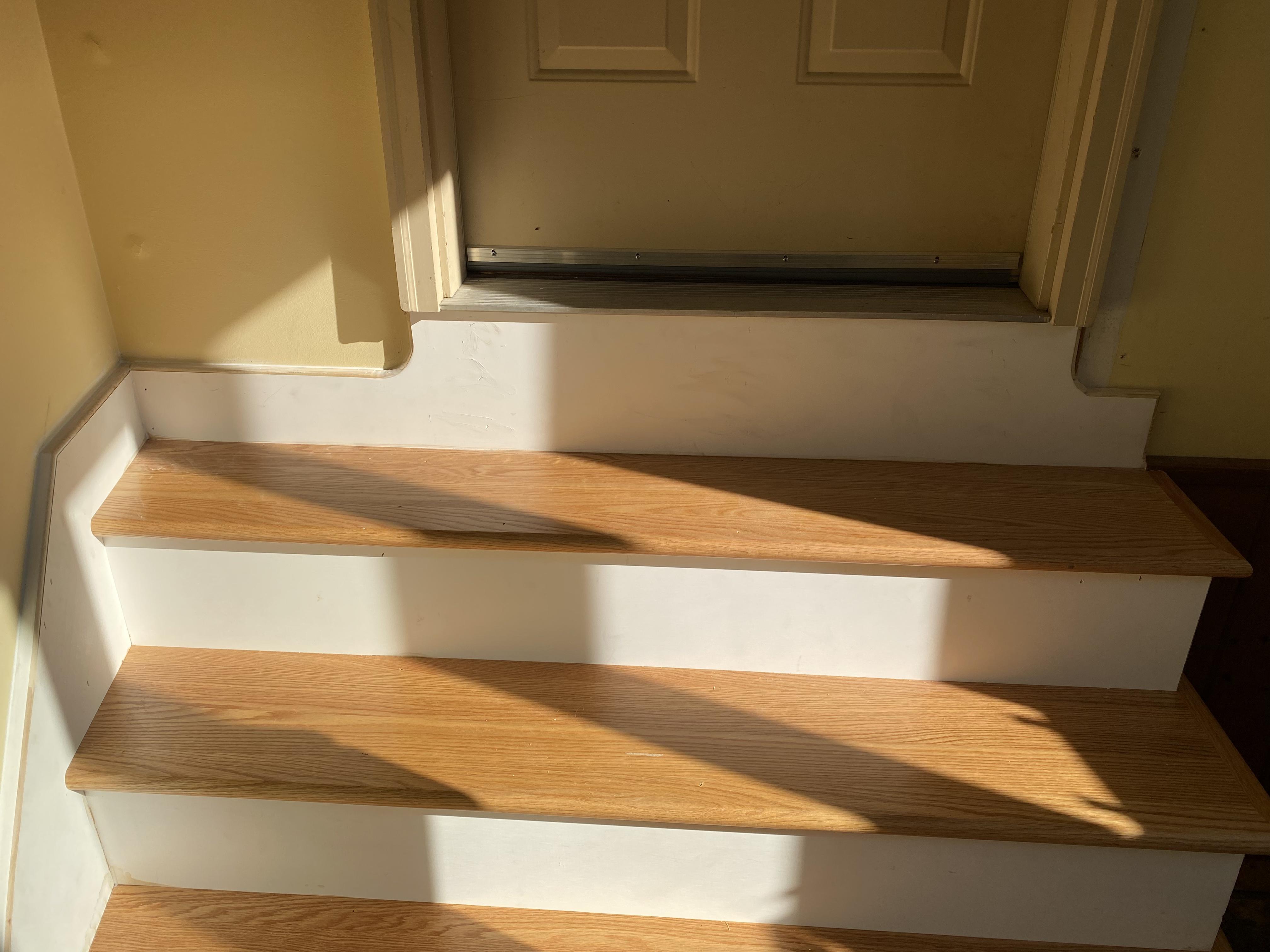 After — red oak stair treads with white painted risers and clean landing at top of stairs