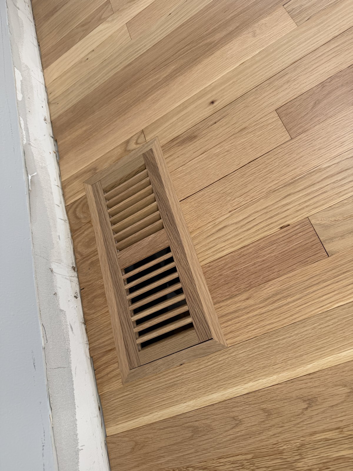 Portsmouth RI — flush-mount vent craftsmanship detail on the finished white oak floor