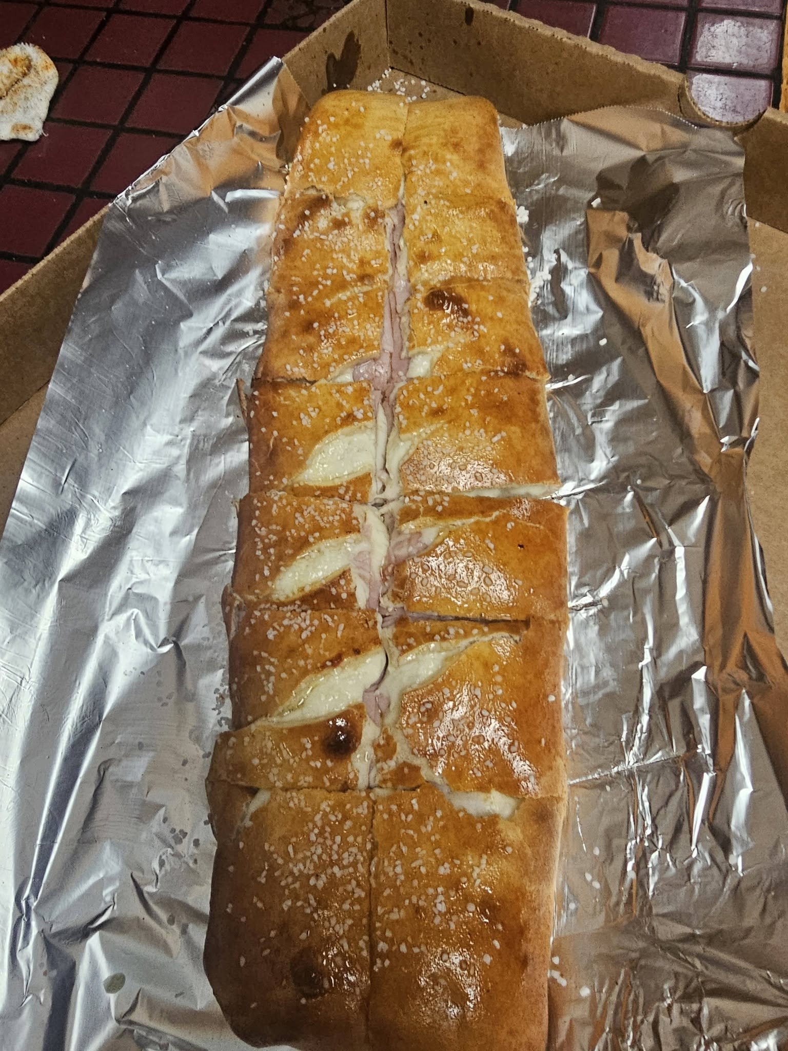 JoJo's Pretzel Boli cut open showing ham and mozzarella