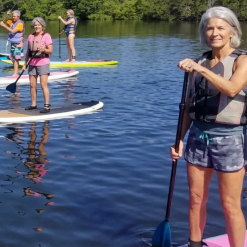 Woman paddleboarding on Lido Key after acupuncture treatment for fibromyalgia at AcuMed Clinic Sarasota