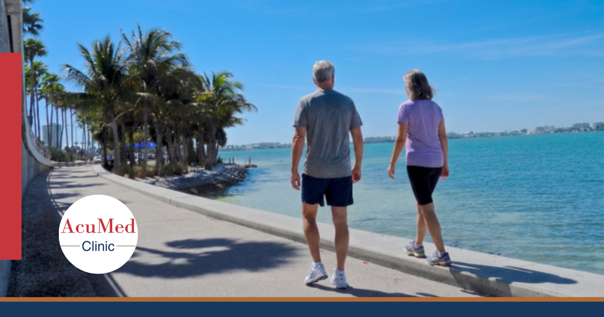 Couple walking along the Sarasota waterfront after foot pain treatment at AcuMed Clinic