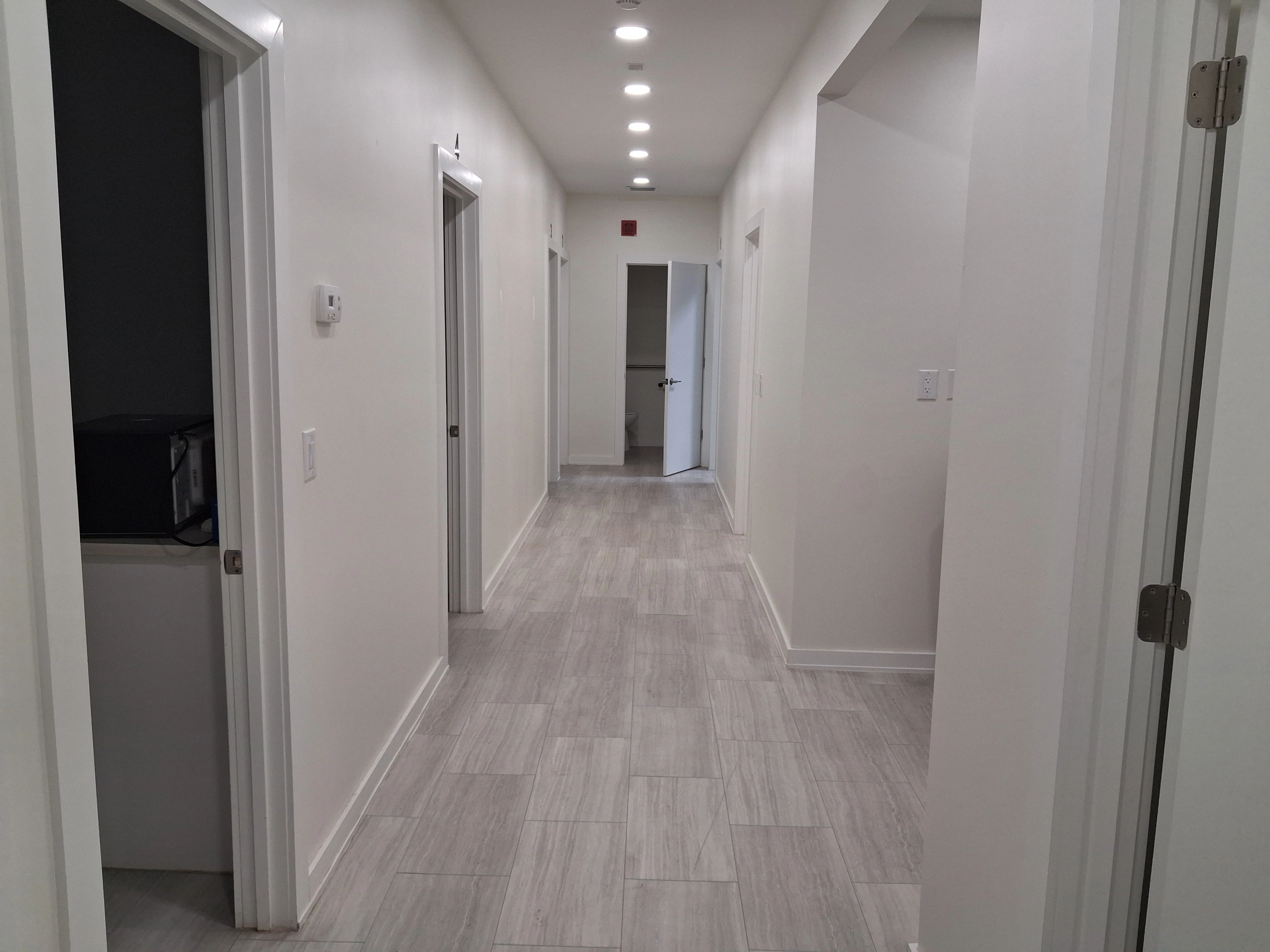 Bright interior hallway leading to private treatment rooms at AcuMed Clinic