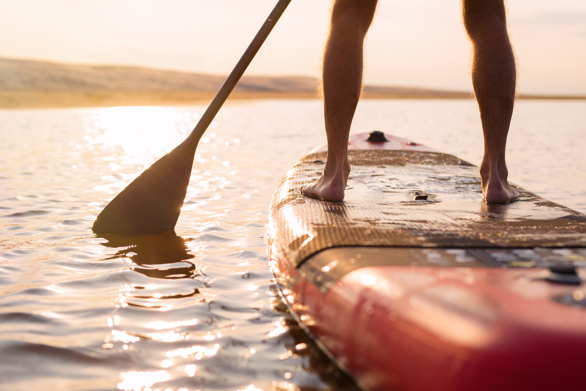 Paddleboarding on calm water at sunset — the kind of activity fibromyalgia patients at AcuMed Clinic in Sarasota return to