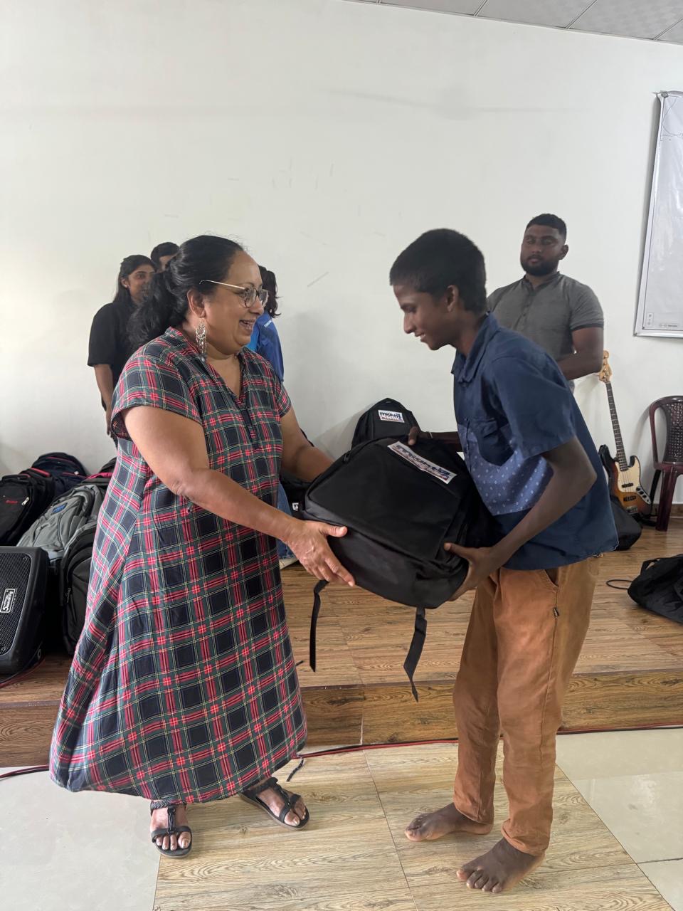 P61 team member giving a backpack to a student in Sri Lanka
