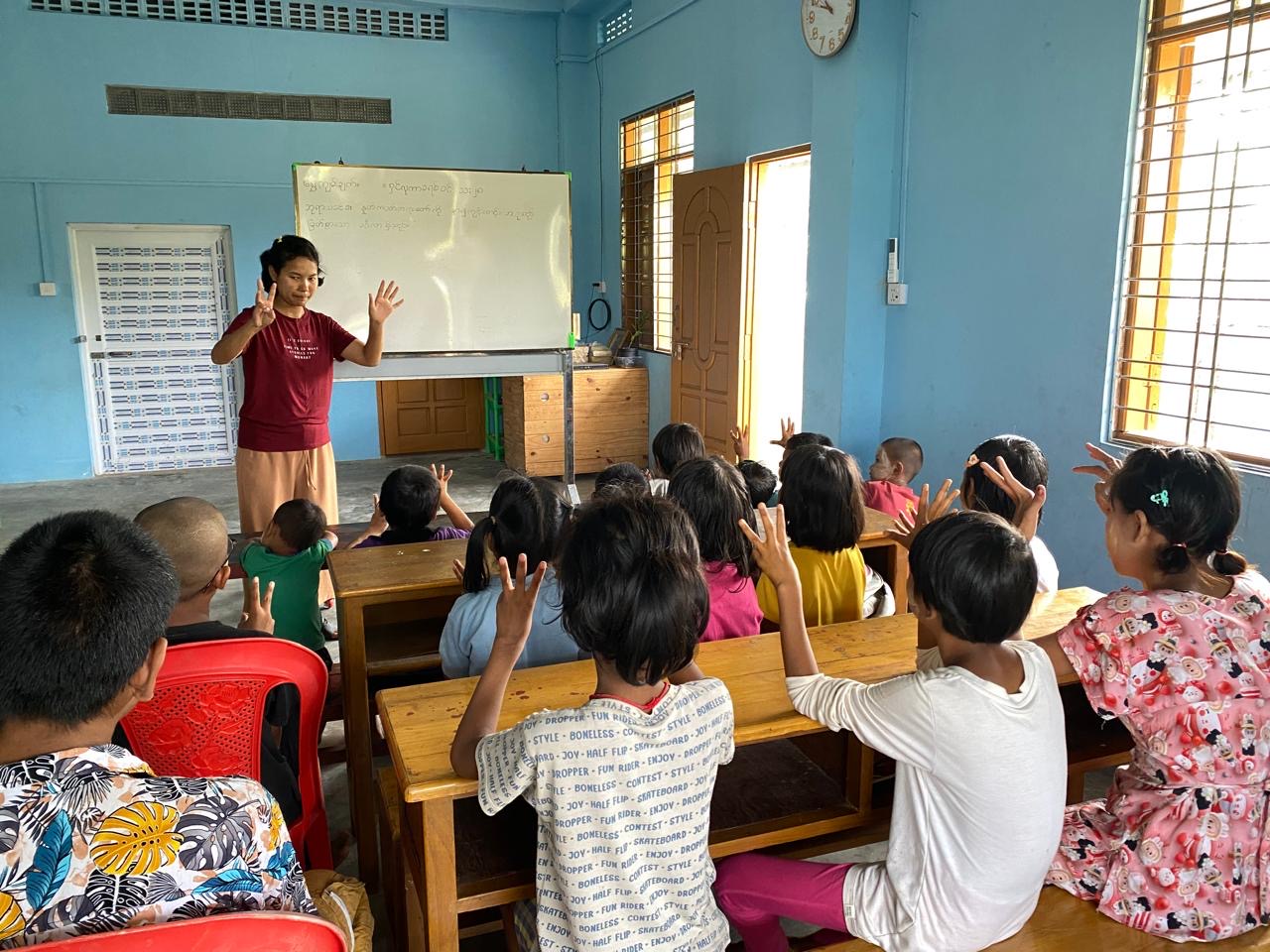 Teacher leading an interactive classroom session with children in Myanmar