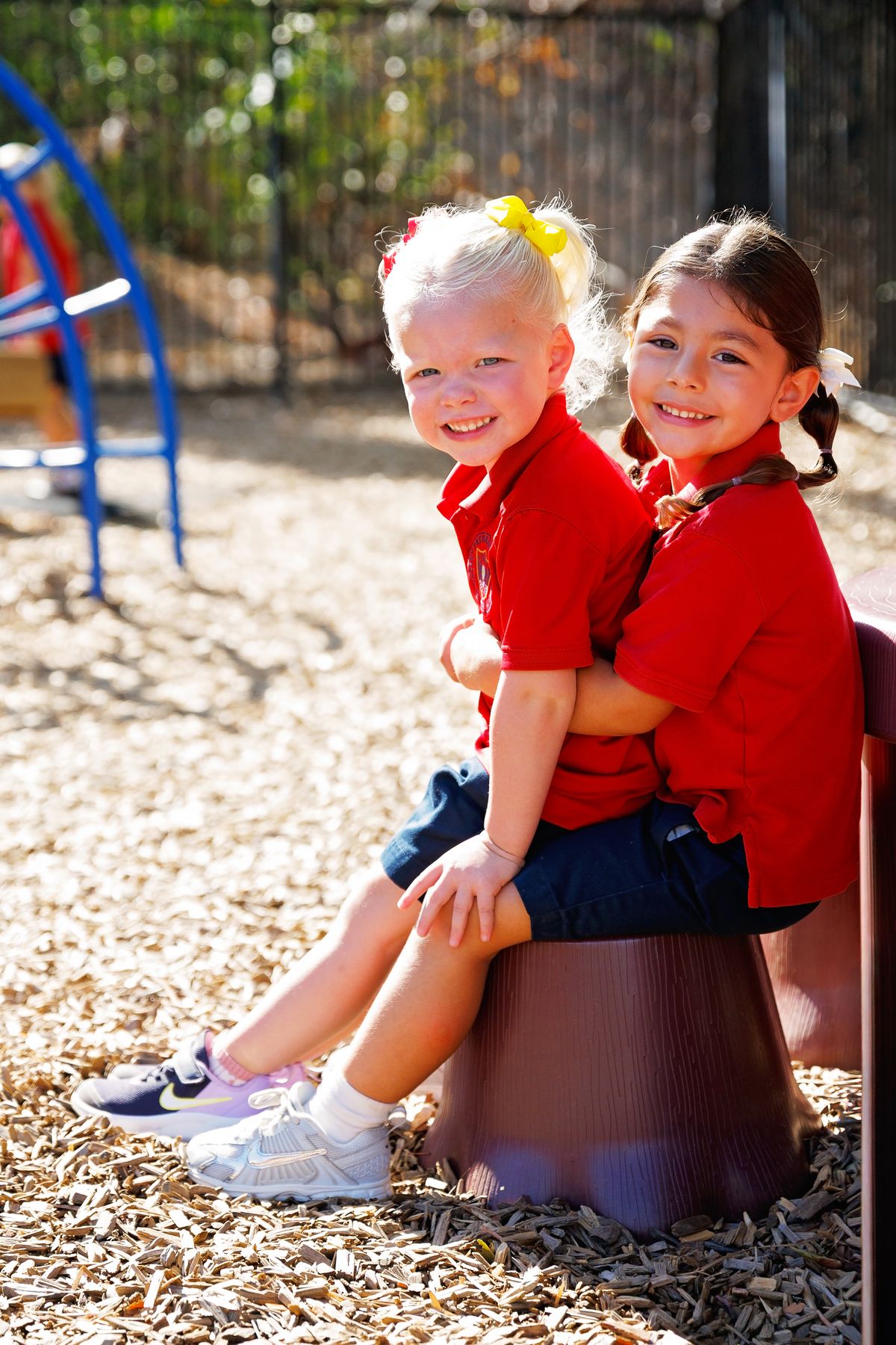 Two of Valley Prep's youngest students sit together on the playground