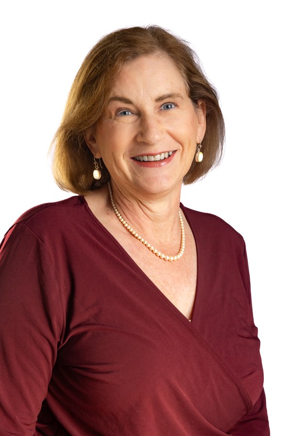 Professional headshot of a woman with light brown hair, maroon top and pearl necklace — Houston LinkedIn headshot