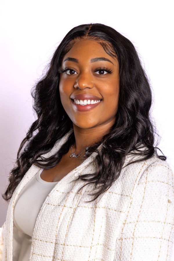 Professional headshot of a smiling woman with dark hair and a white plaid jacket — Houston branding headshot