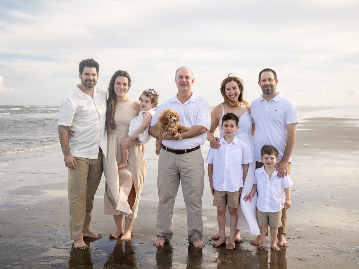 Three-generation family portrait on the beach with their dog