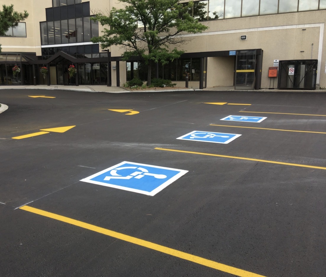 Commercial parking lot with yellow lines and handicap stalls