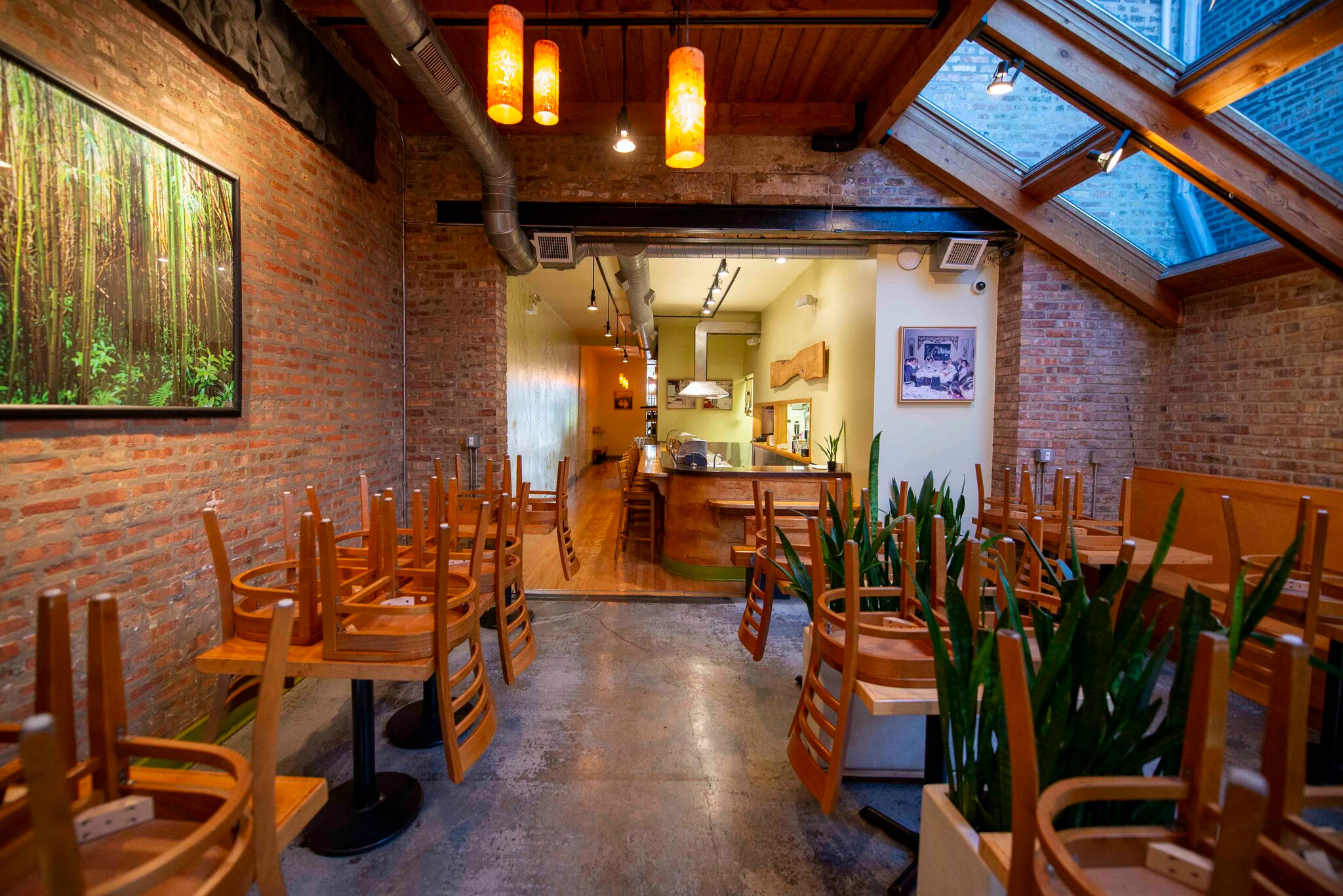 Dining room with skylights, exposed brick walls and bamboo artwork at 1829 W Chicago Ave