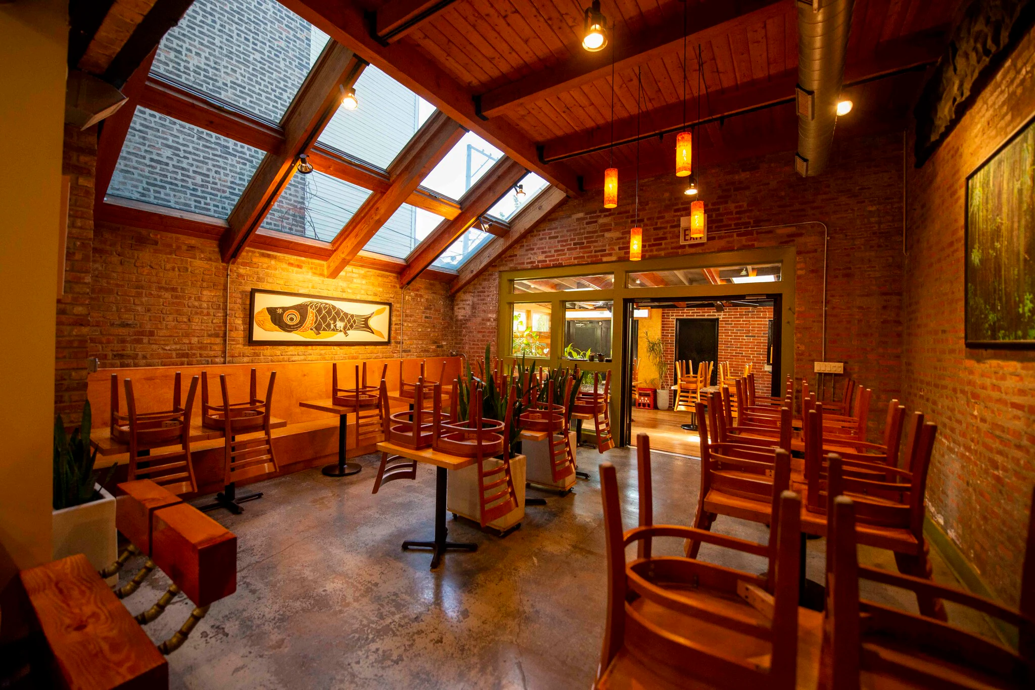 Dining room with high wood-beamed ceiling, skylights and framed art at 1829 W Chicago Ave