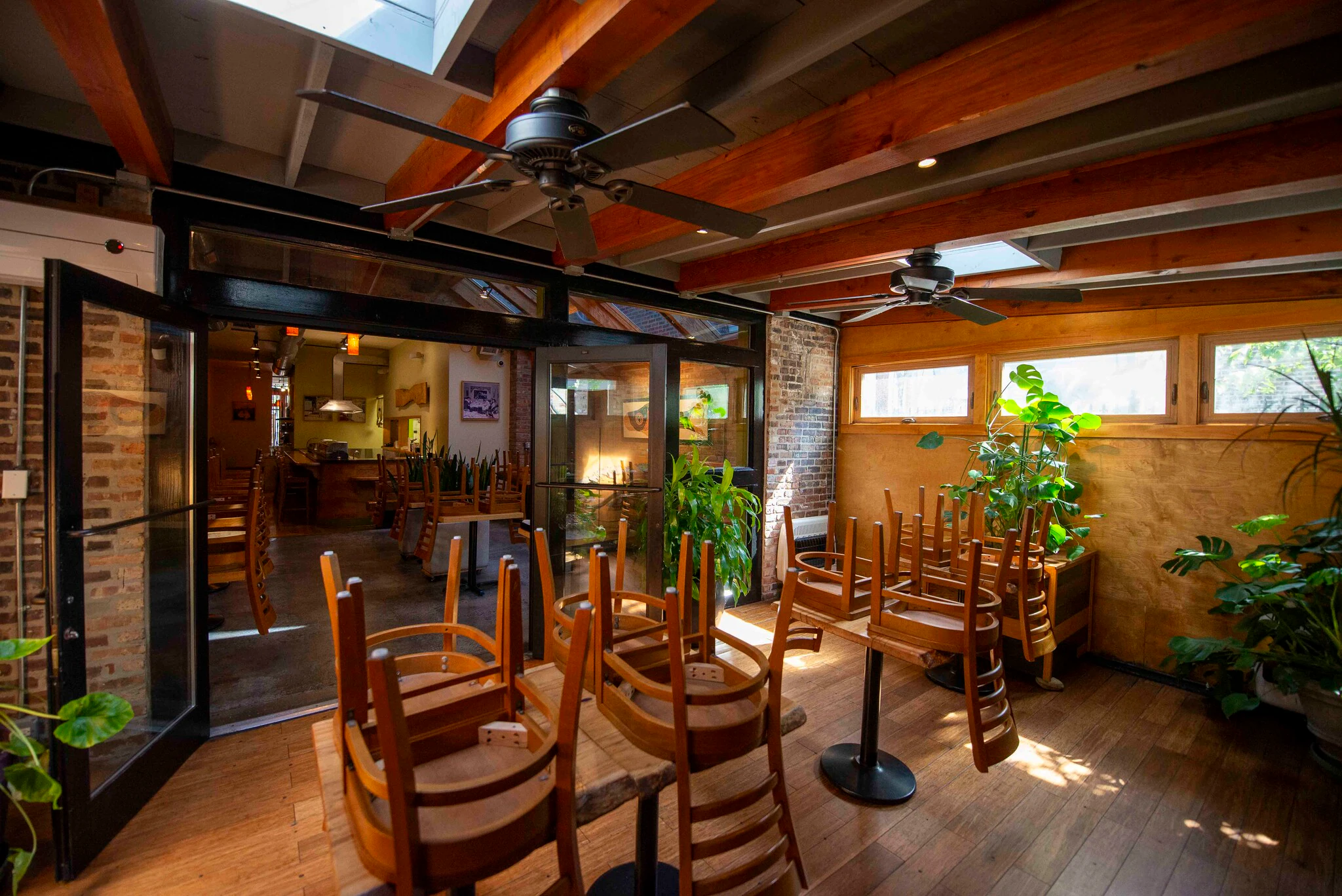 Dining room with exposed brick, wood beams, ceiling fans and glass doors at 1829 W Chicago Ave
