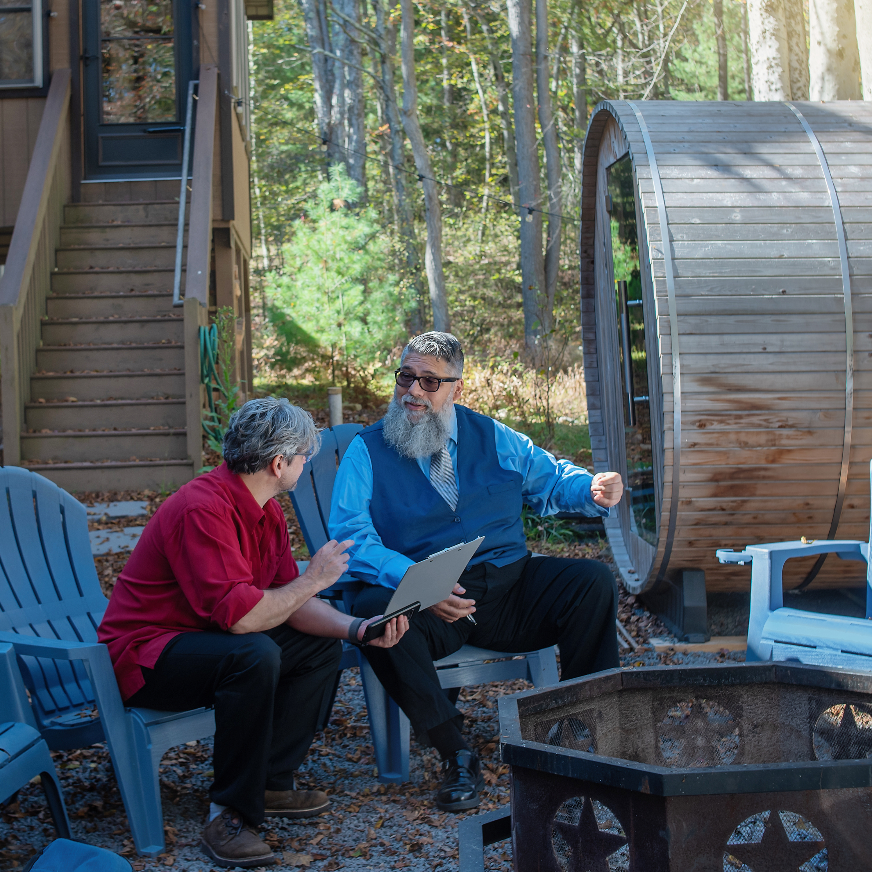 Personal Delivery Specialist consulting with customer next to a barrel sauna and firepit