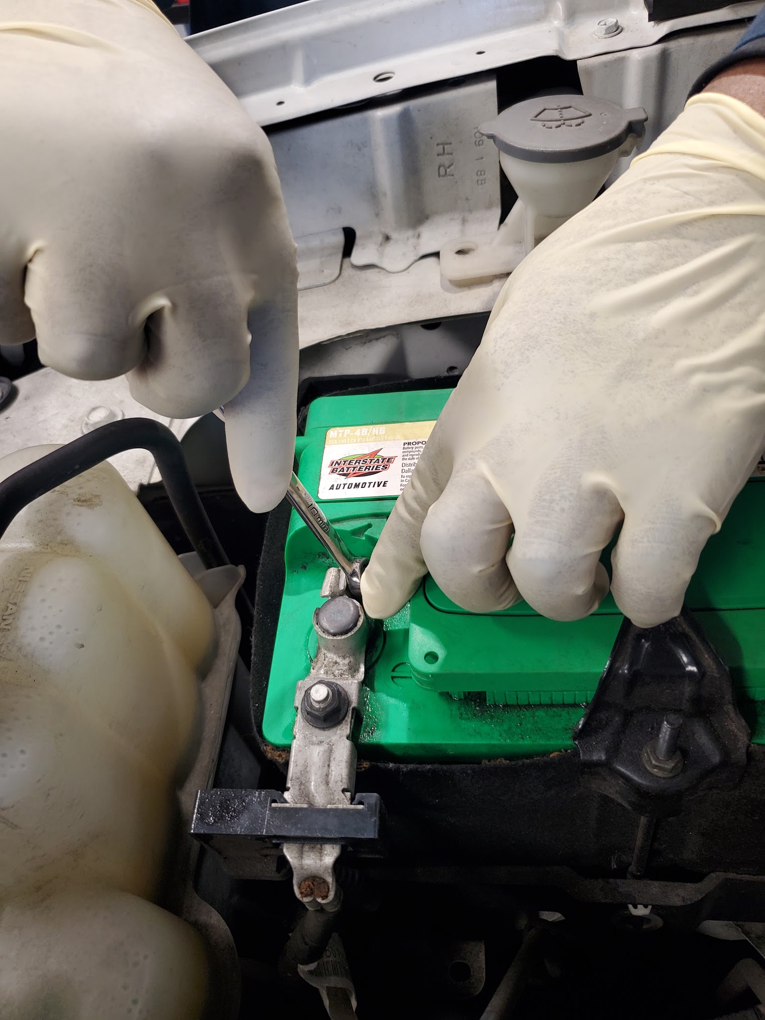 SAP Auto Repair technician servicing a battery