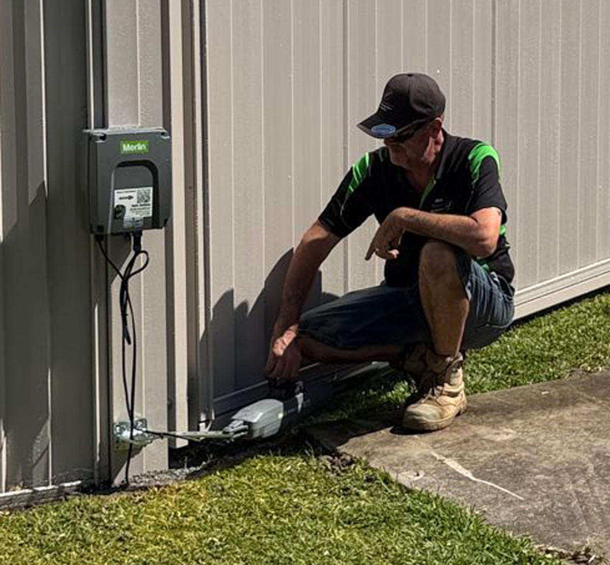 Matt installing a Merlin swing gate motor at ground level on a Gold Coast residential property