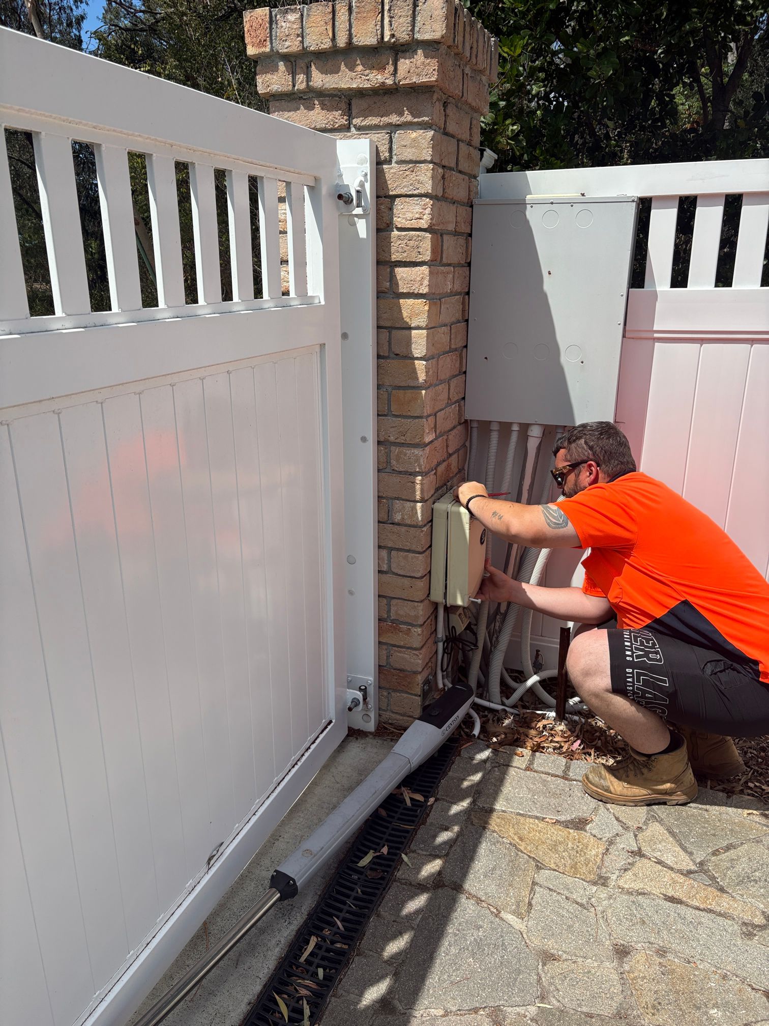 Technician installing a Centsys Vantage 500 swing gate motor on a residential property