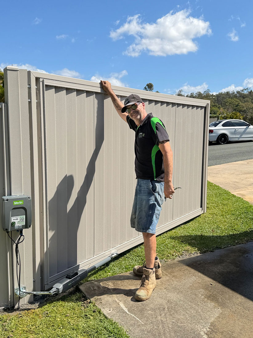 Matt from Into Action Automation standing next to a completed Merlin automatic swing gate motor installation on the Gold Coast