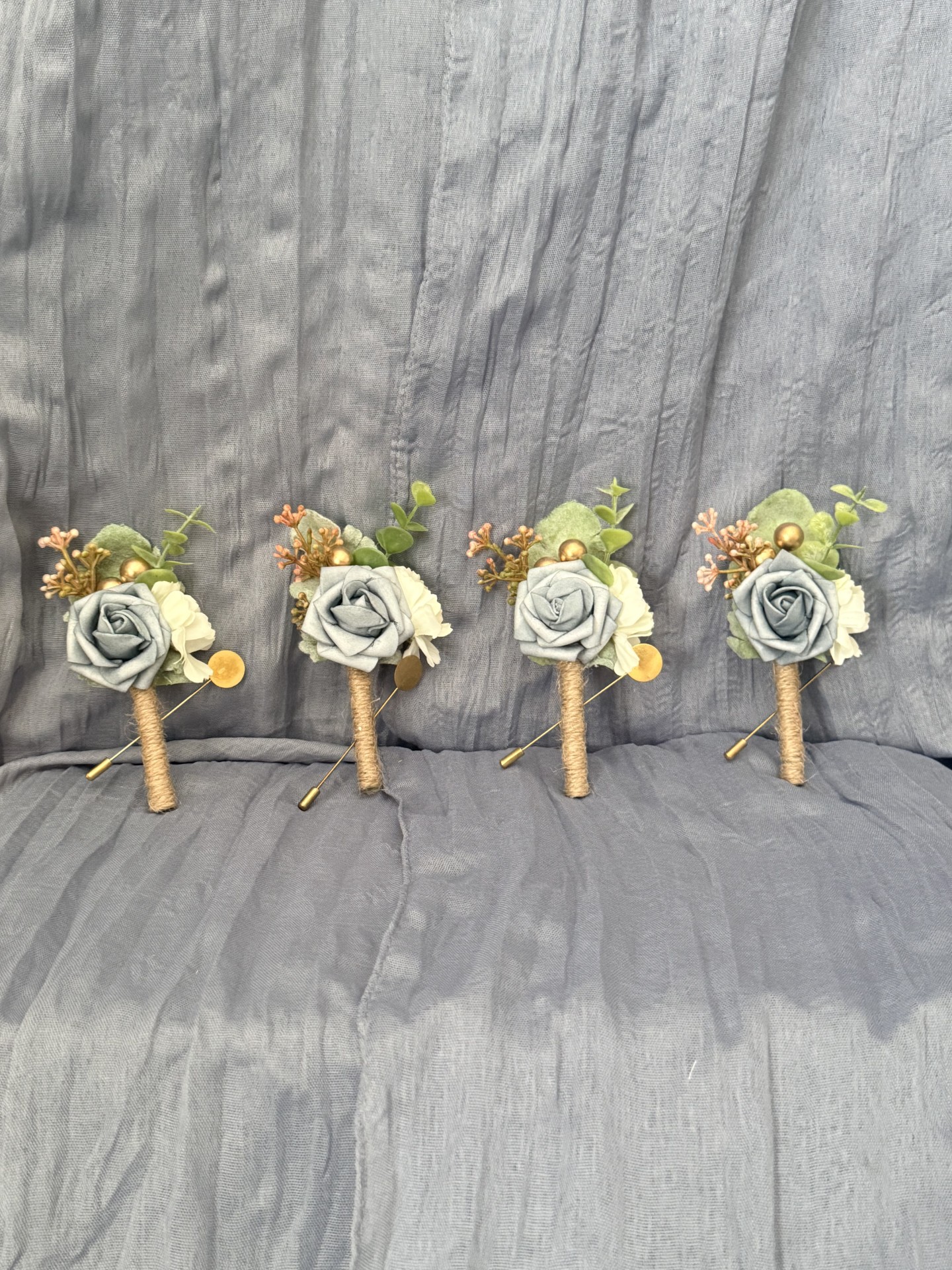 Dusty blue rose boutonnieres with eucalyptus and gold accents wrapped in twine by Petal Essence in DFW