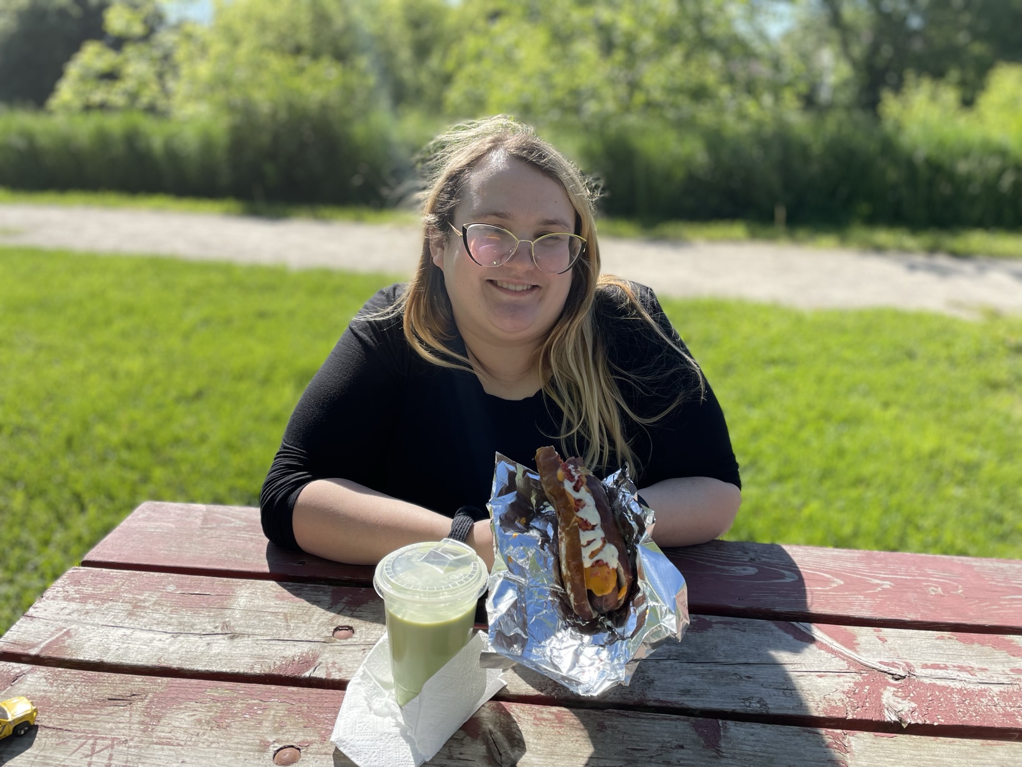 Happy customer with a gourmet hot dog and lemonade