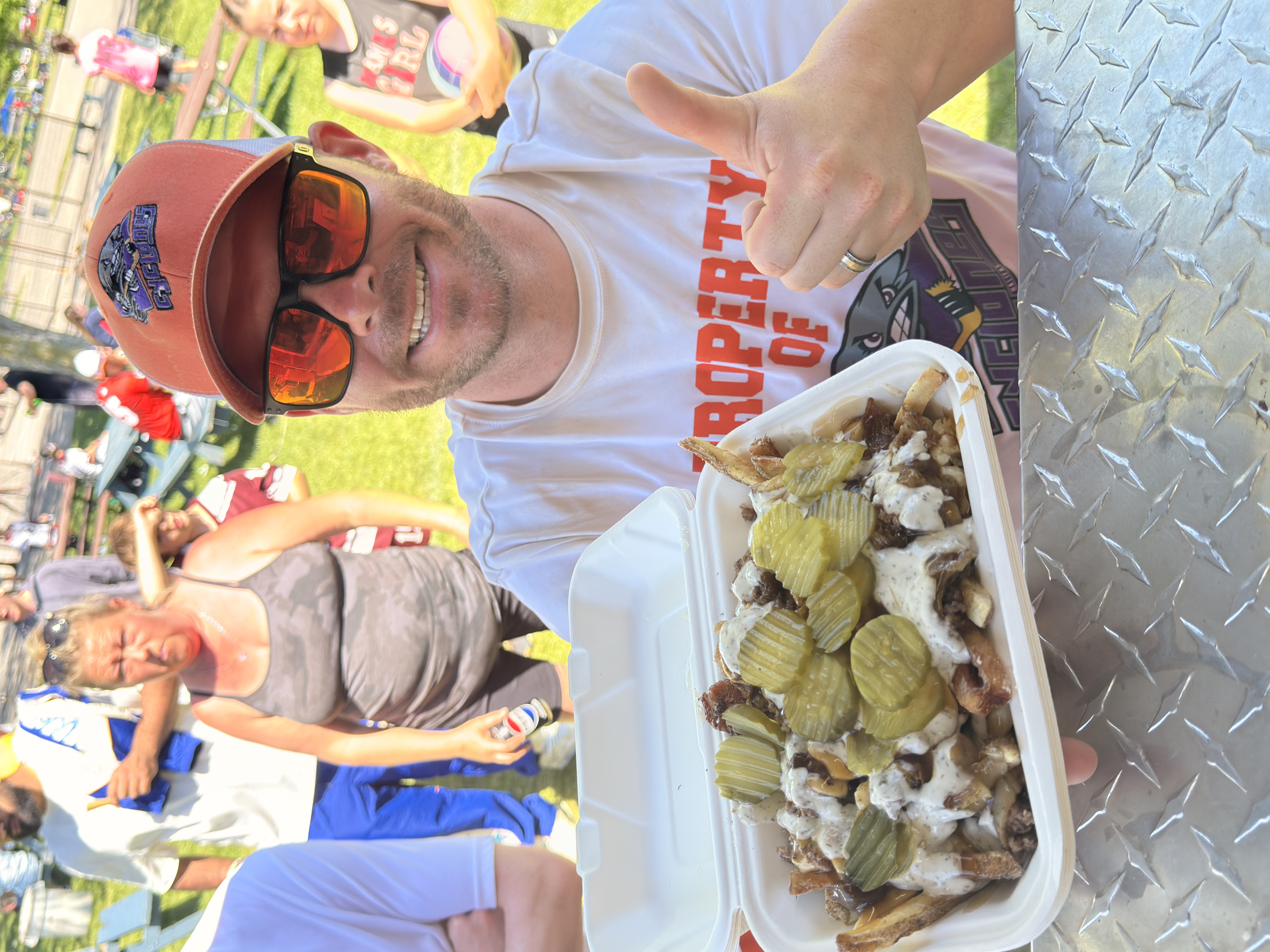 Customer holding dill pickle fries and giving a thumbs up