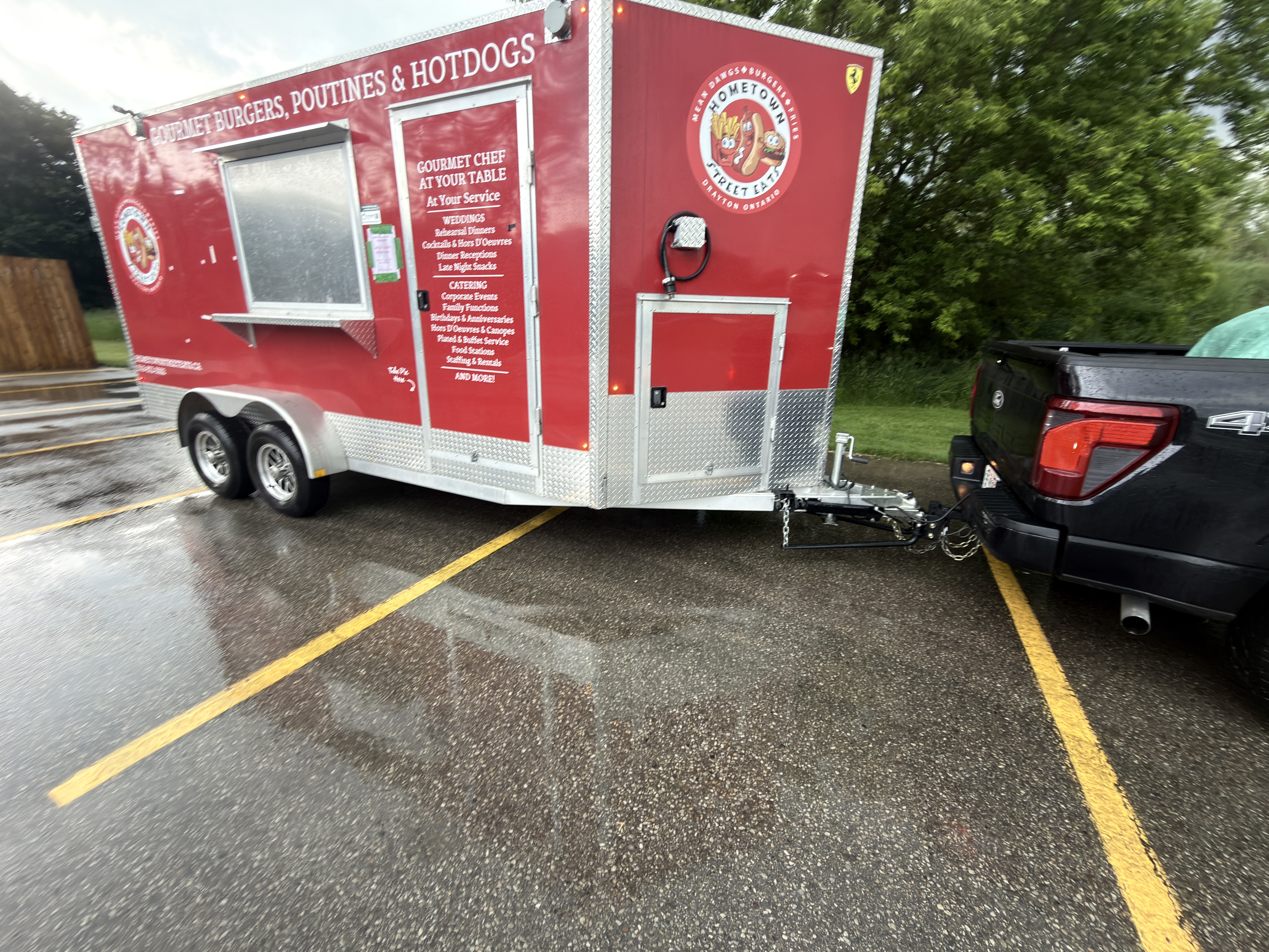 Hometown Street Eats trailer rear view hitched to truck showing catering services list