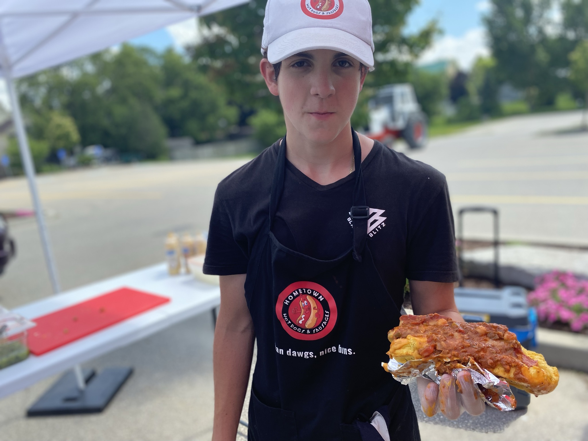 Daniel holding a loaded gourmet hot dog
