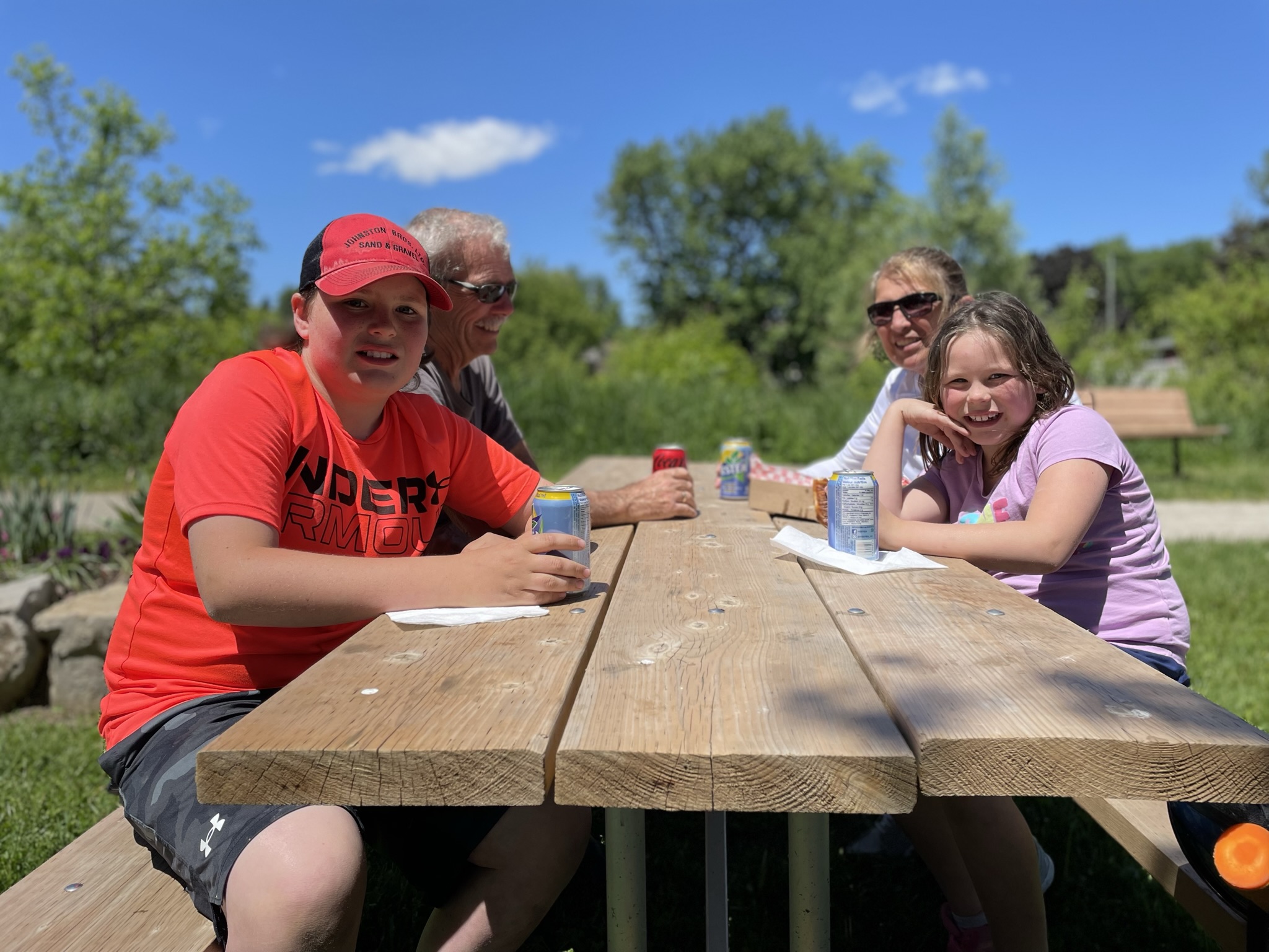 Family with kids enjoying a sunny day at the picnic table