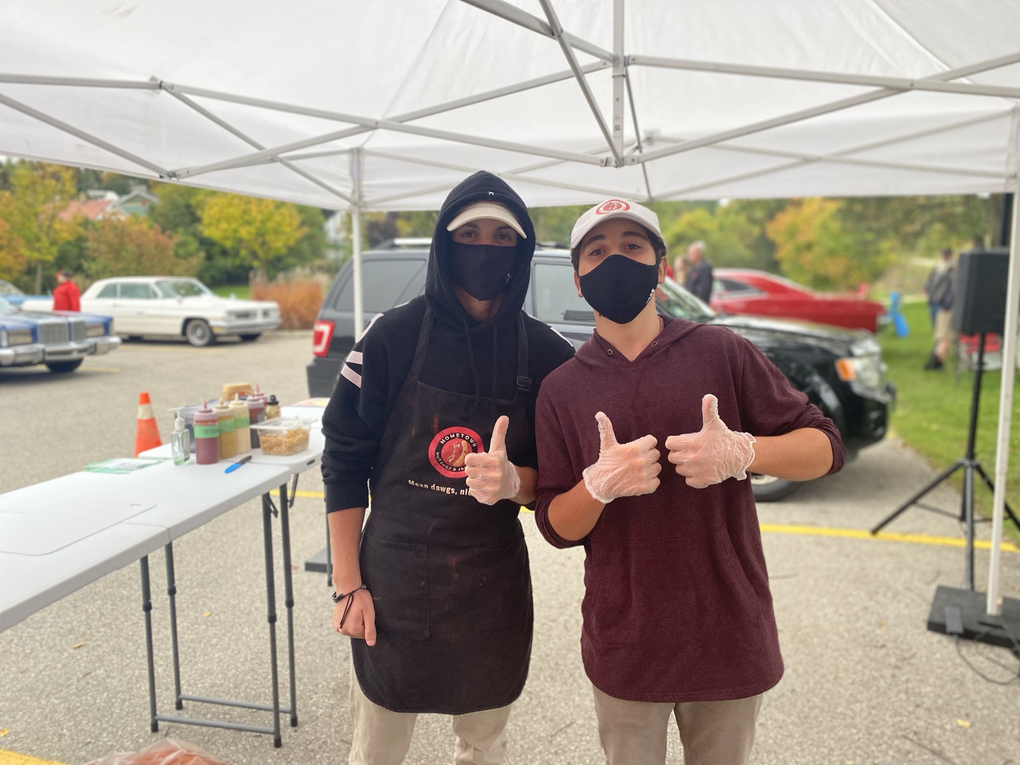 Young crew giving thumbs up at a car show