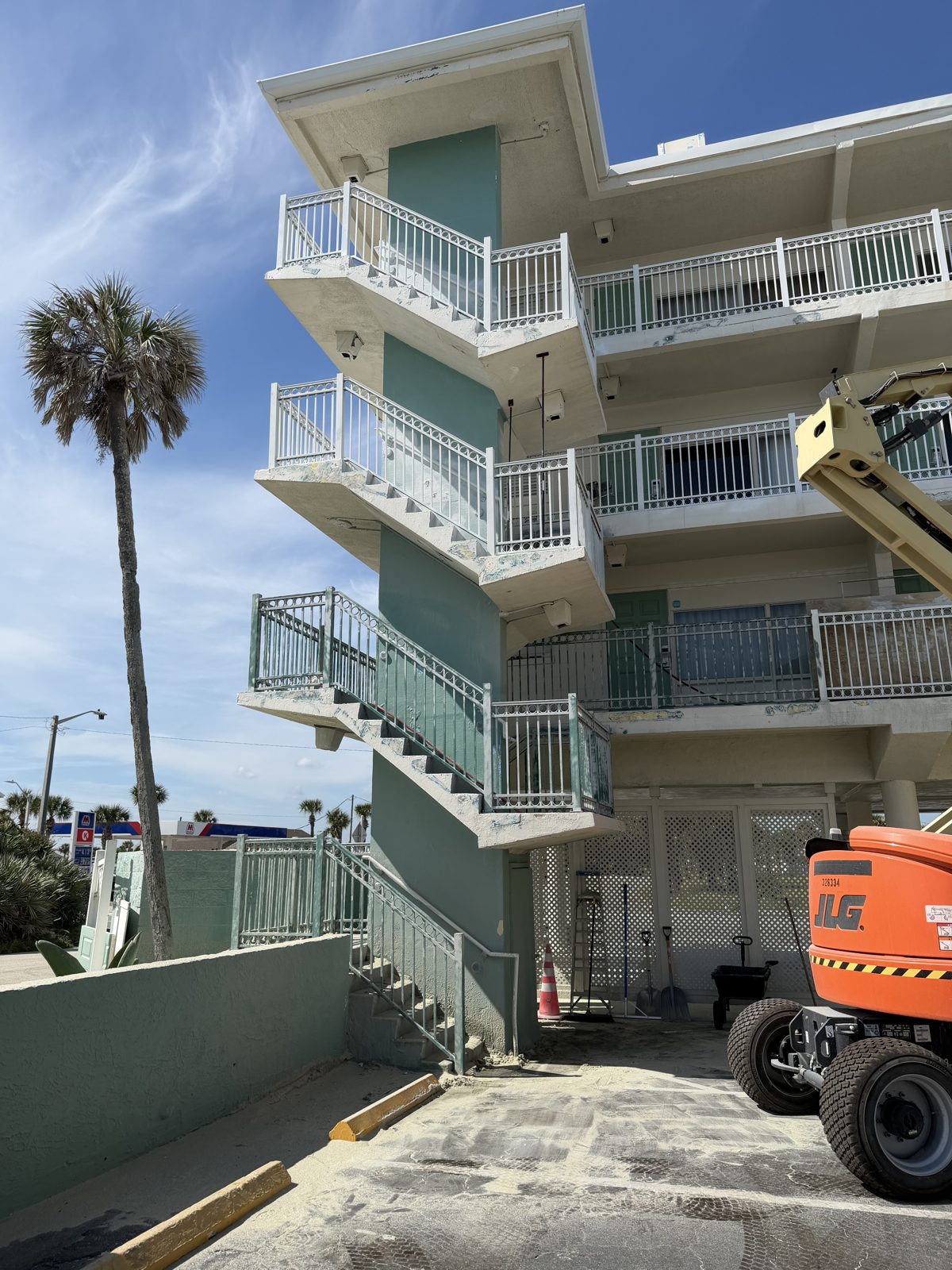 Chateau Mar Resort stair tower before restoration — failed, peeling teal coating on railings and stairs
