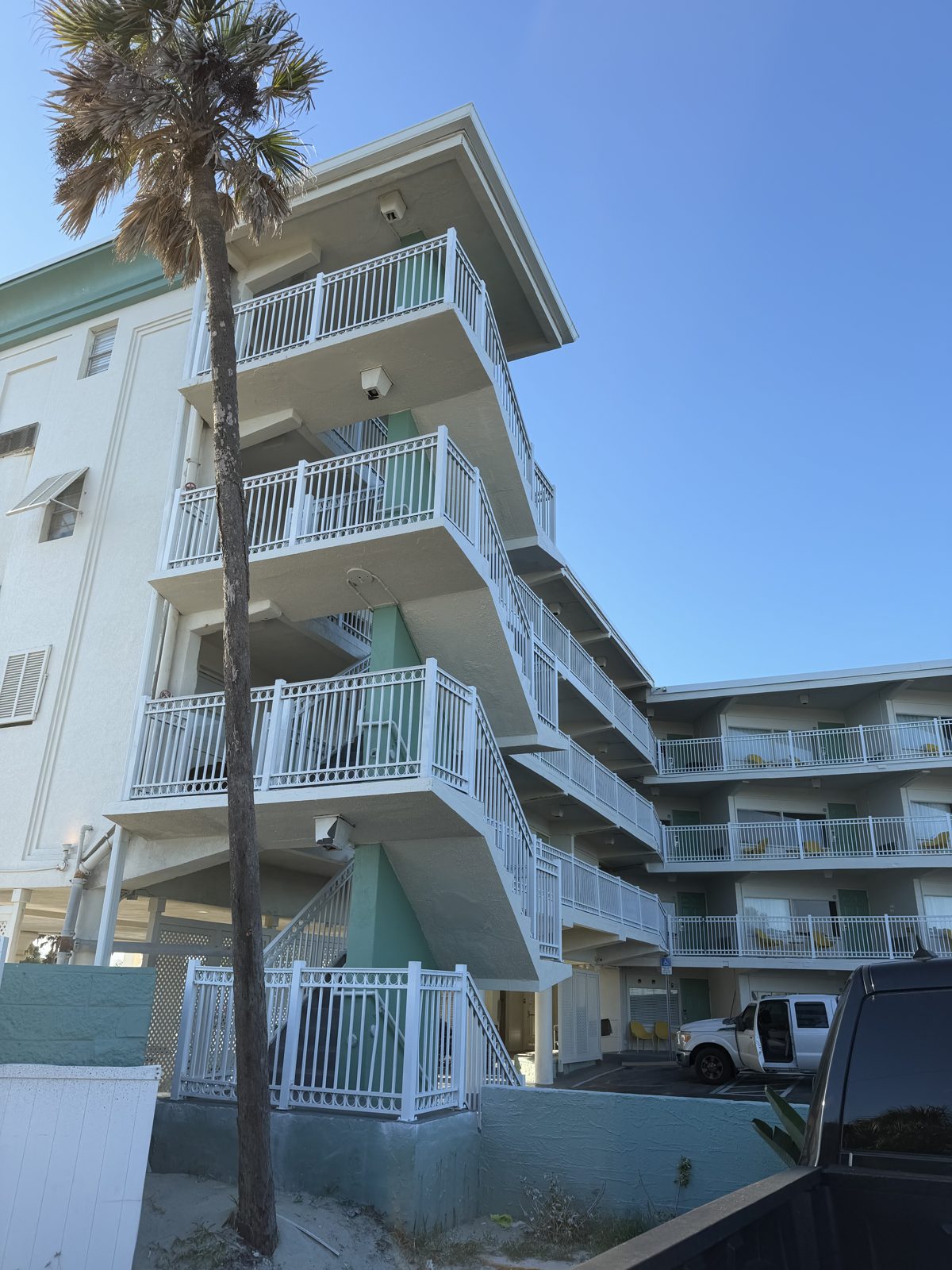 Chateau Mar Resort stair tower after restoration — clean white railings on every flight
