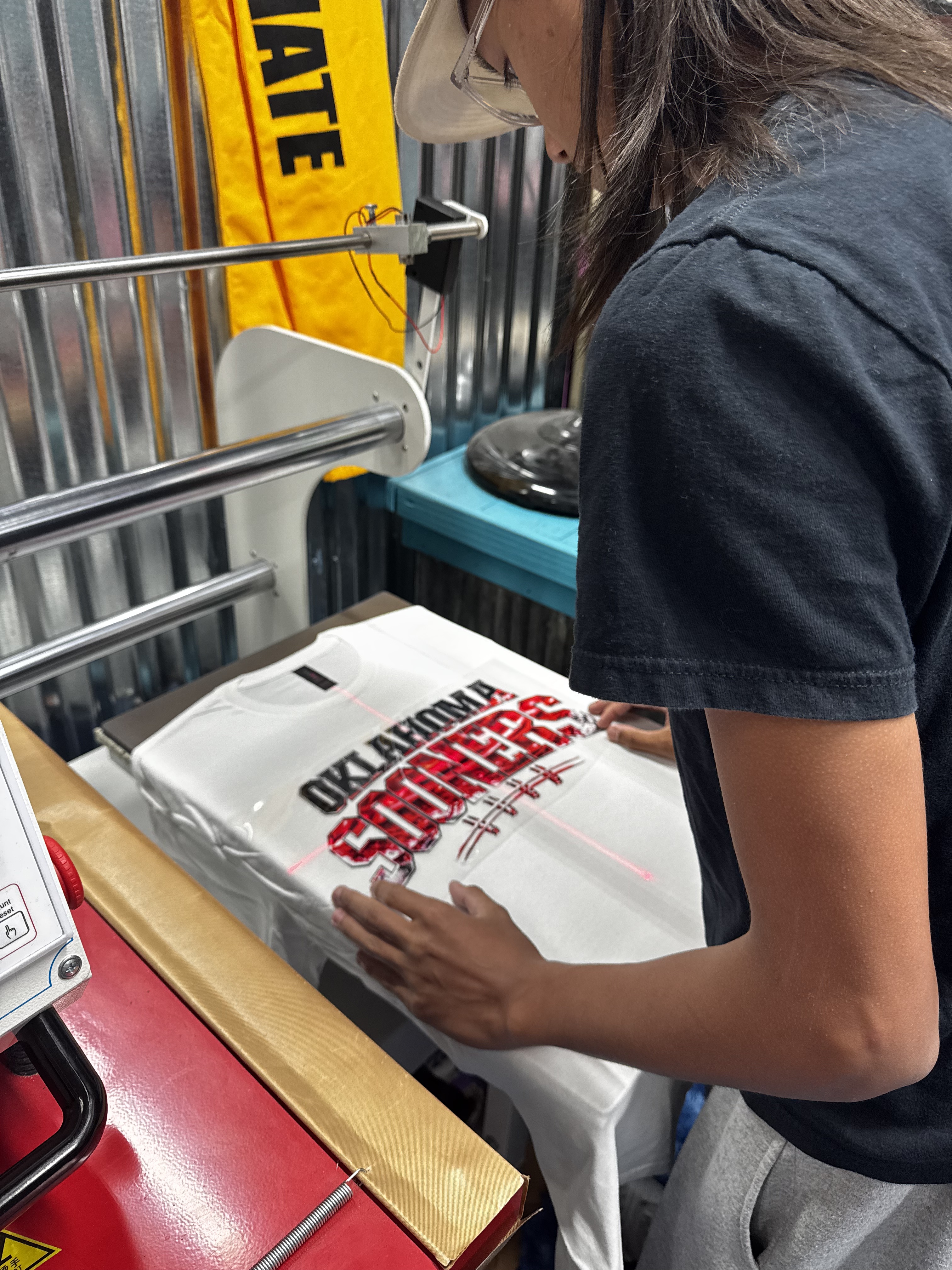 Tyler pressing an Oklahoma Sooners shirt at JP's Custom Design and Printing