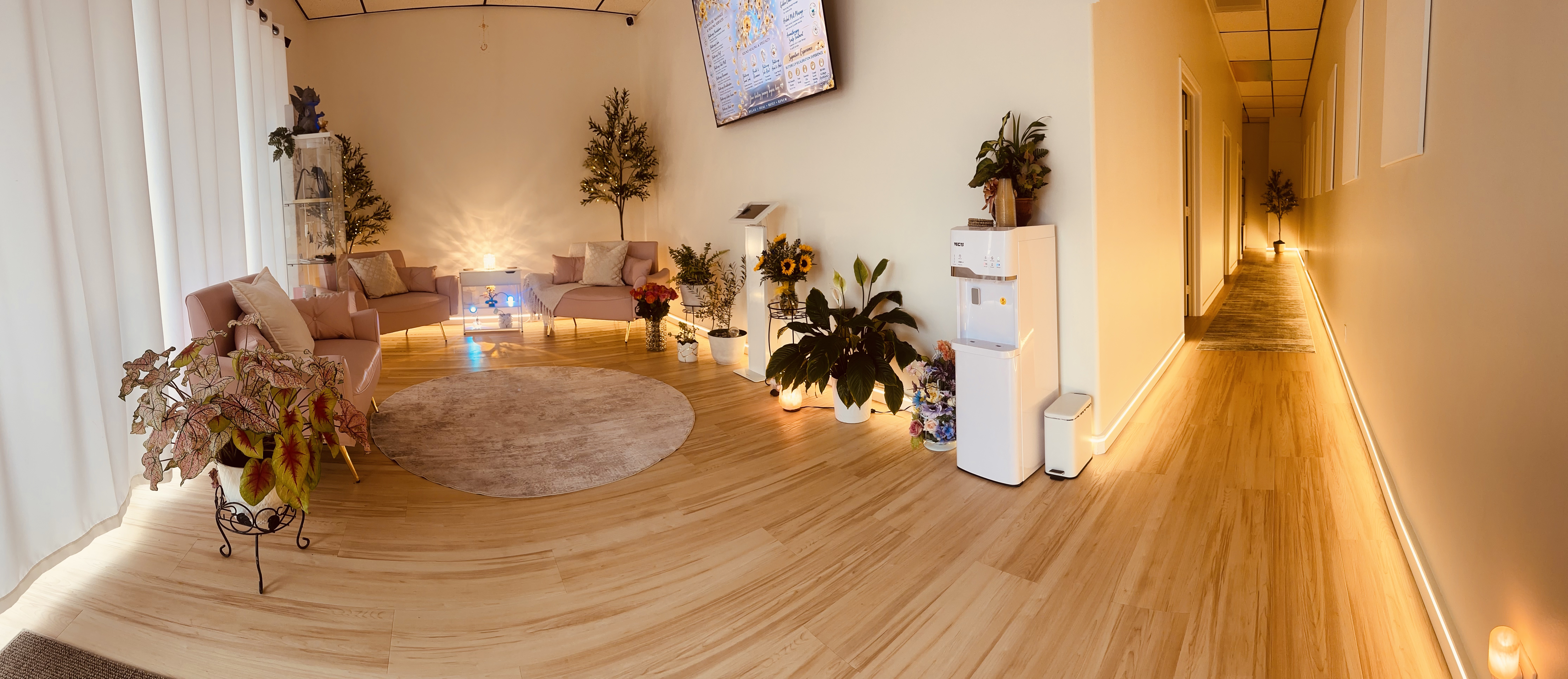 The Busy Goddess Spa — warm, luxurious reception area with plants and soft lighting