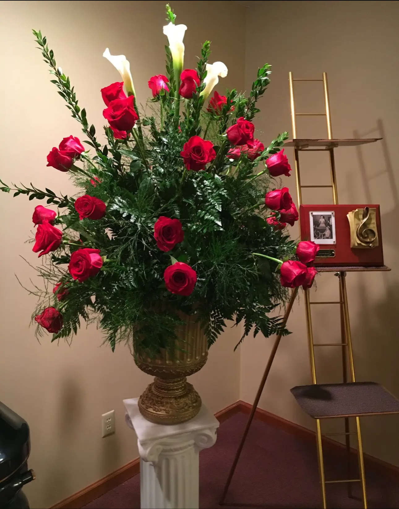 Red roses in gold urn