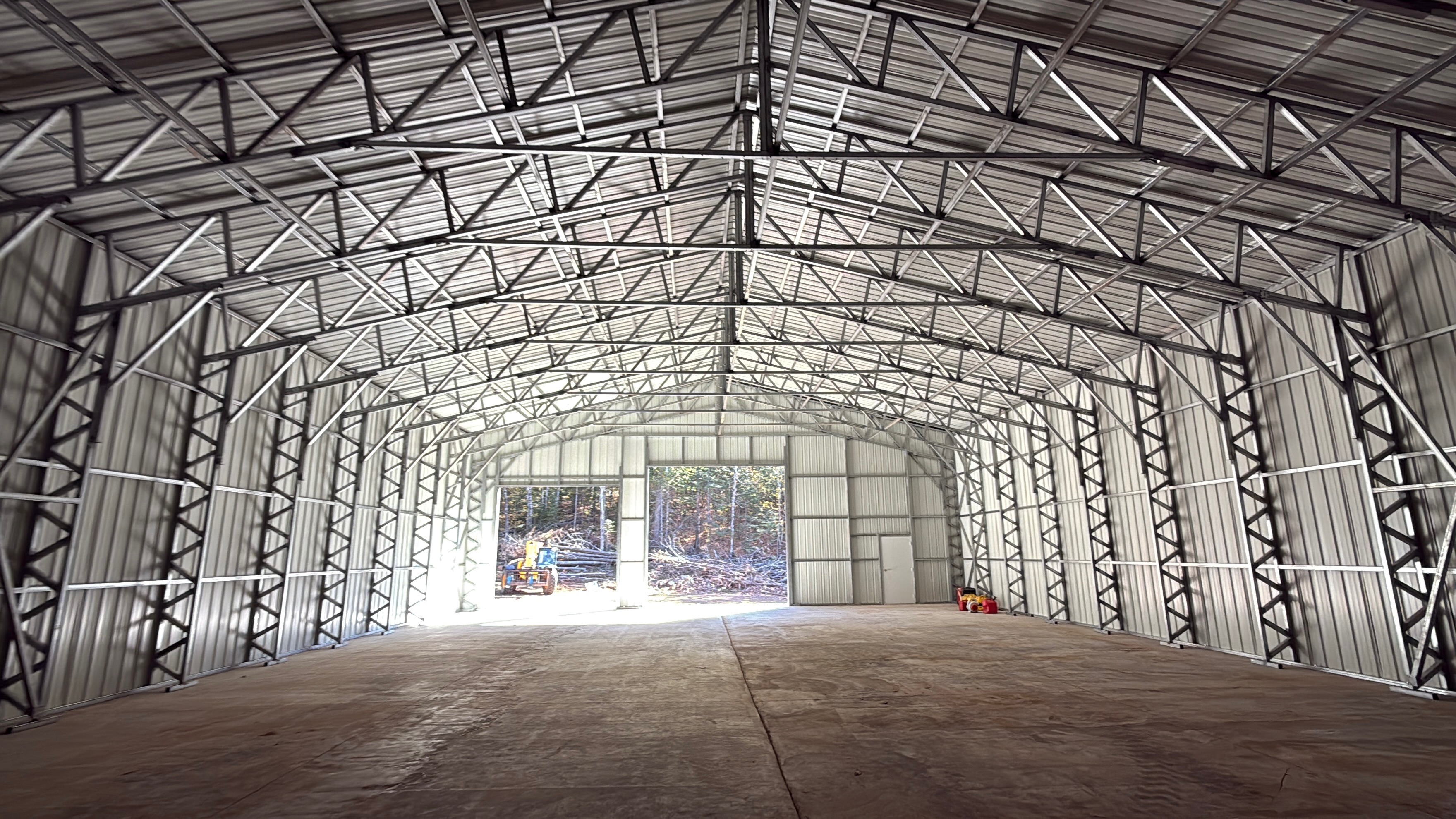 Spacious steel building interior showing impressive truss framework and open bay doors
