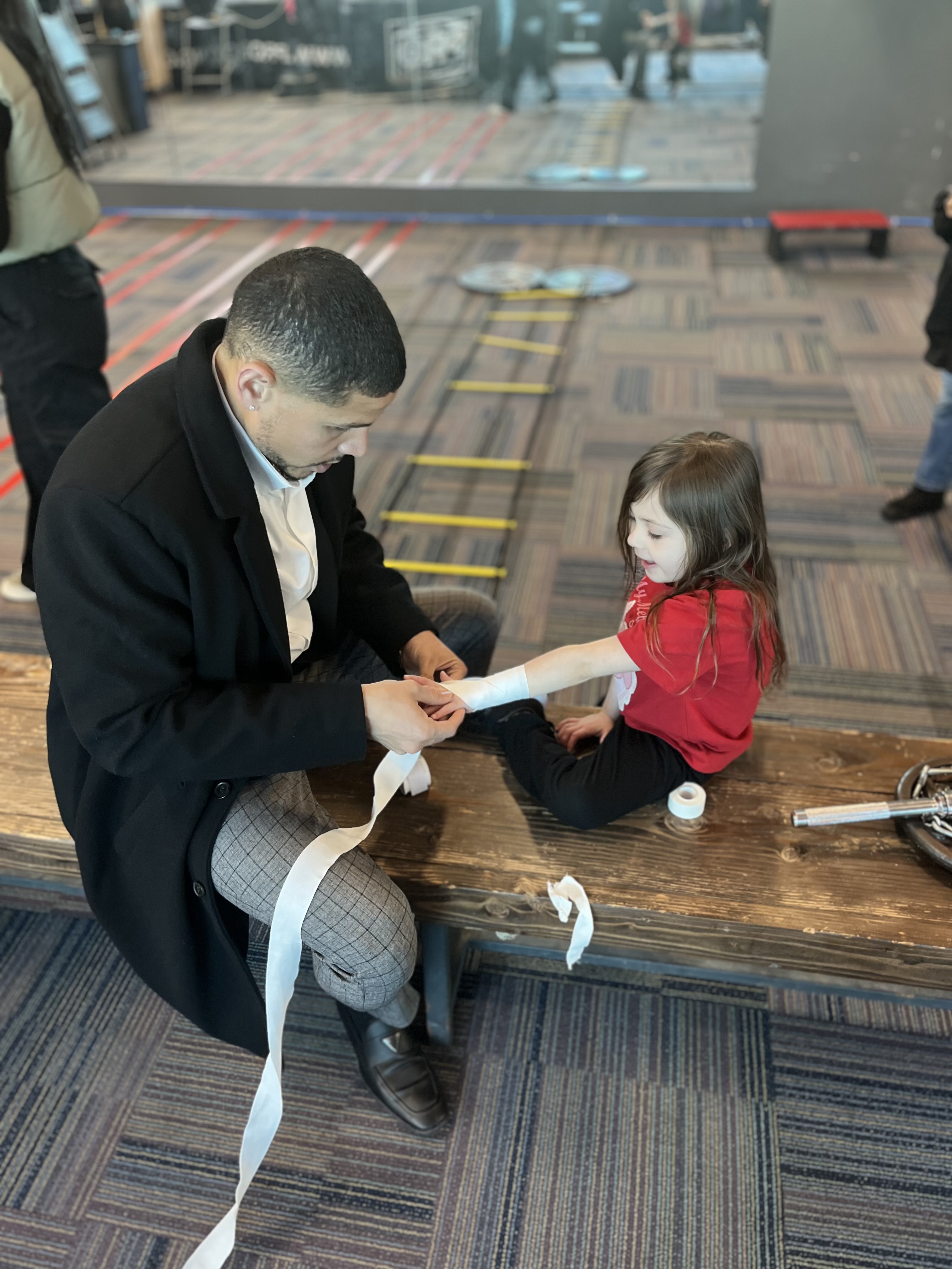 Luis wrapping a young student's hands