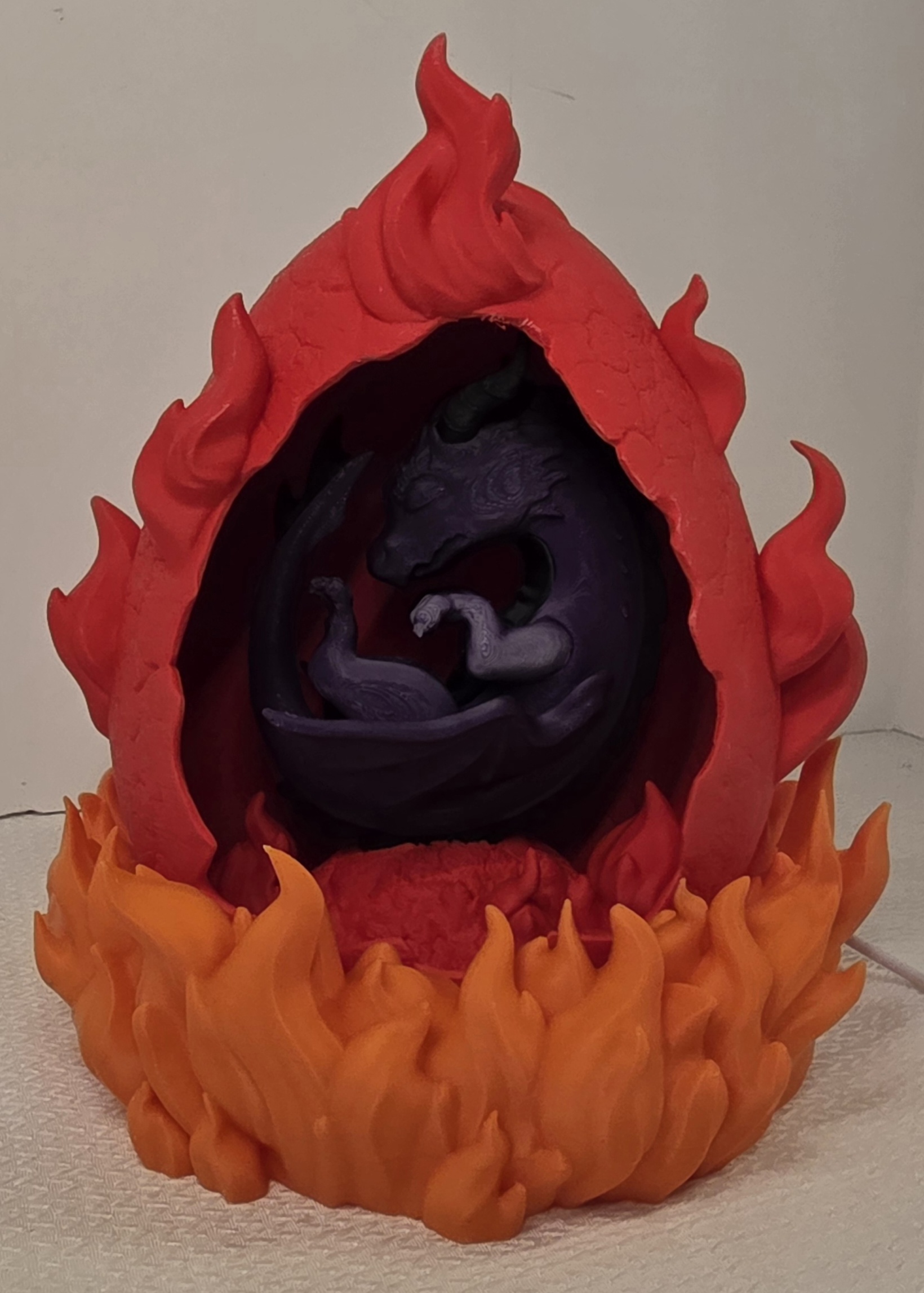 Purple dragon curled inside fire egg with orange and red flames