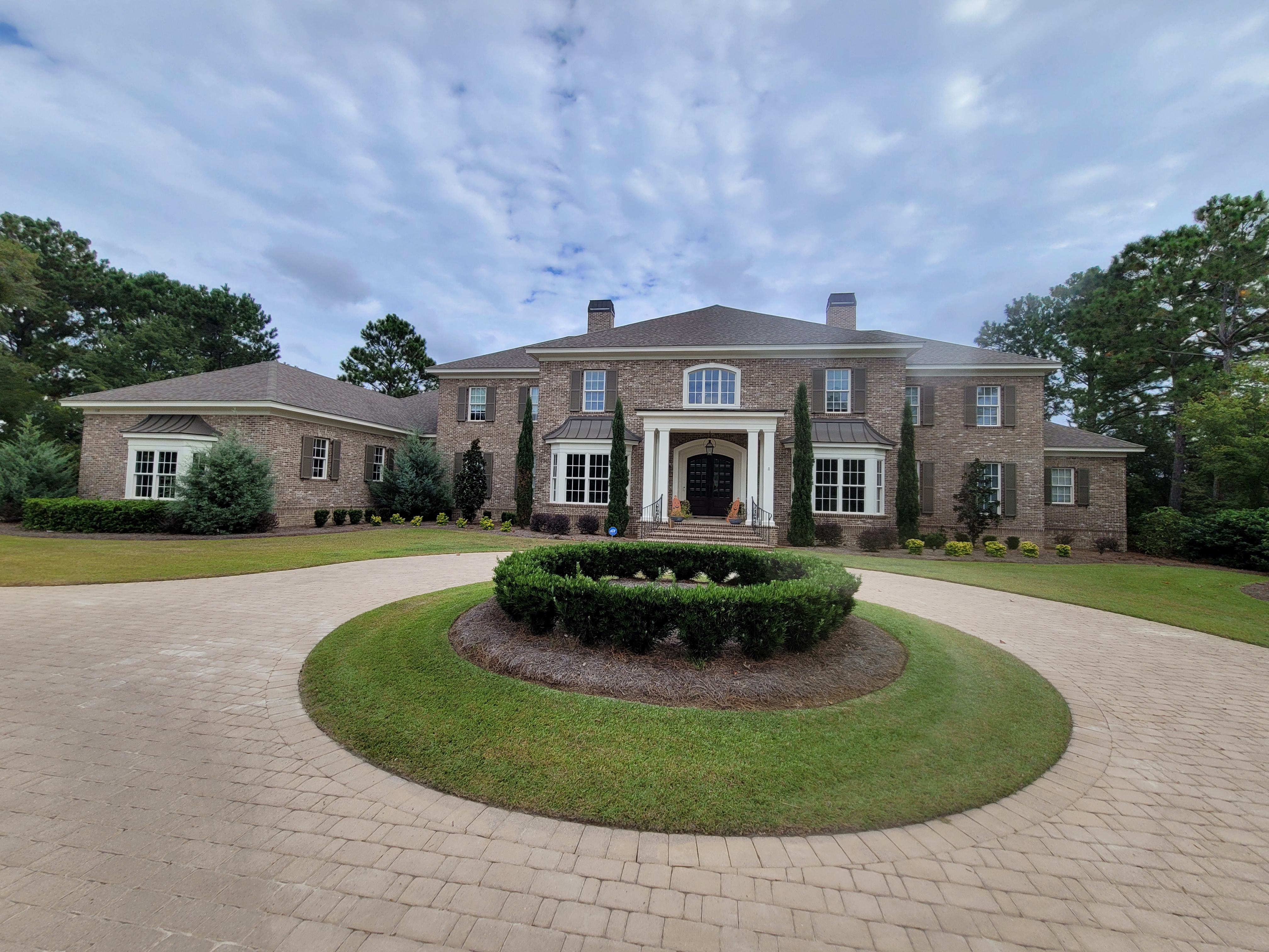 Stunning estate with circular driveway and manicured landscaping by Colonial Landscapes