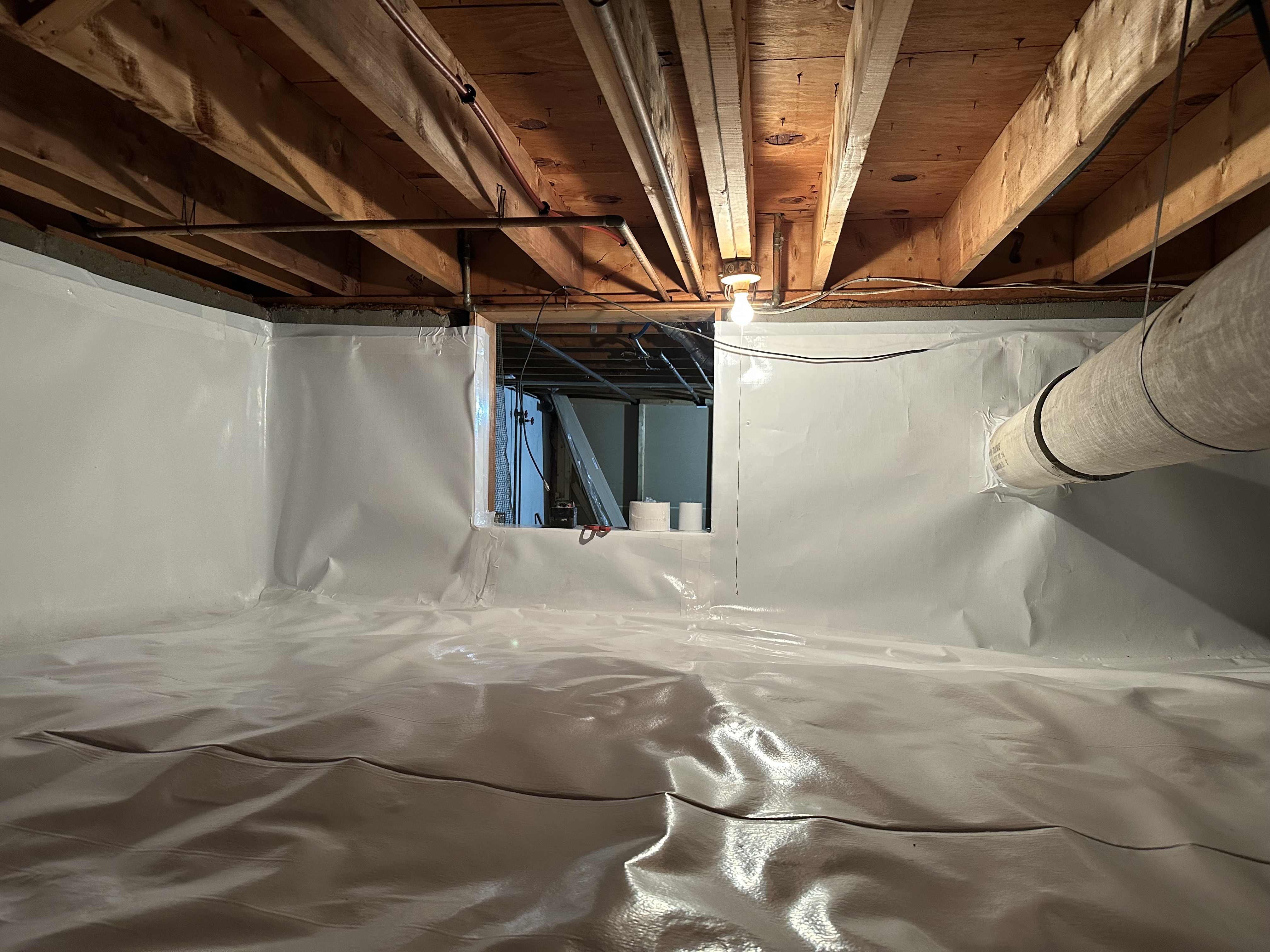 Completed crawlspace encapsulation — walls and floor sealed with 20mil vapor barrier