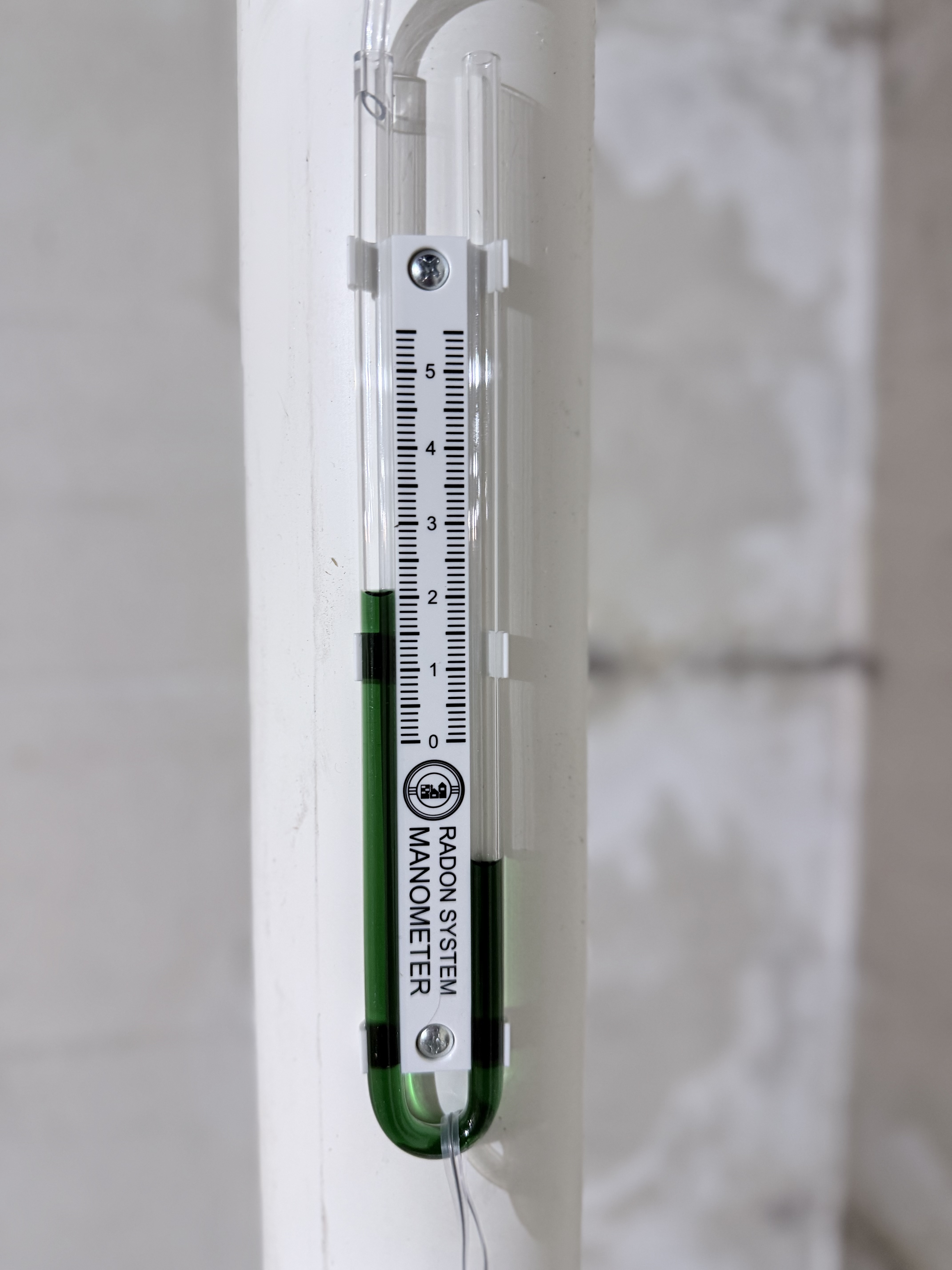 Radon system manometer showing active negative pressure — system is working correctly