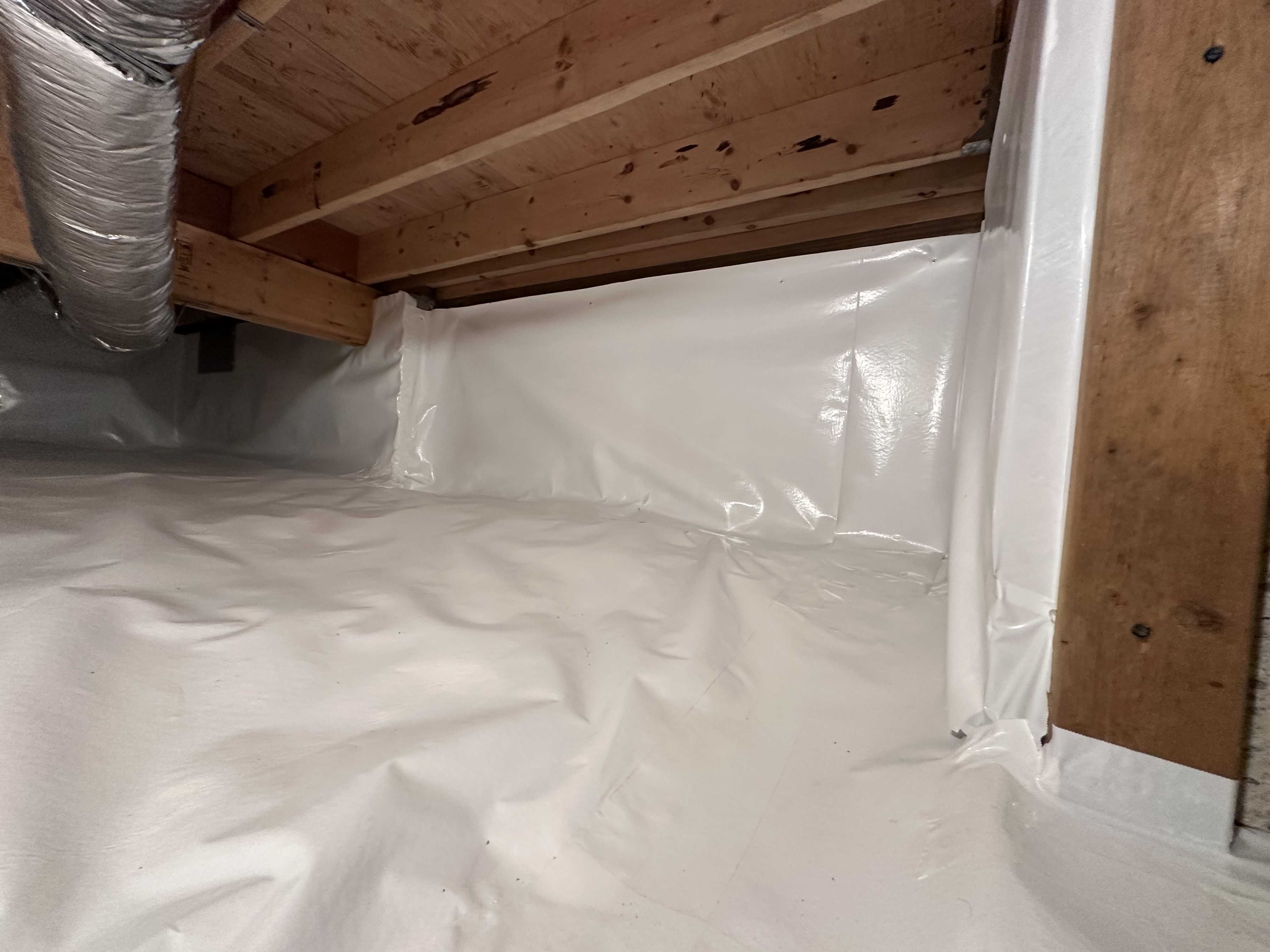 Corner detail of vapor barrier installation — taped seams and wall coverage