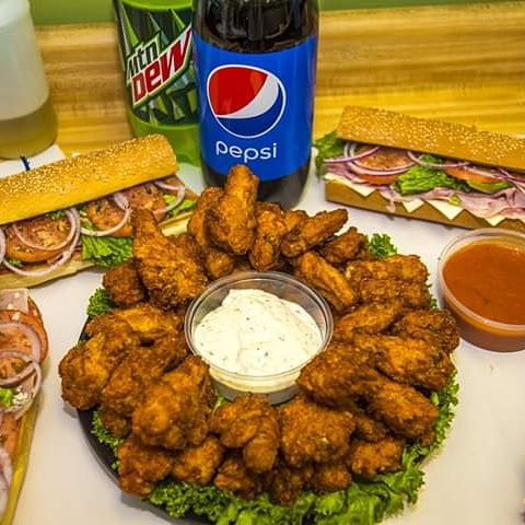 Chicken wings platter with hoagies and drinks