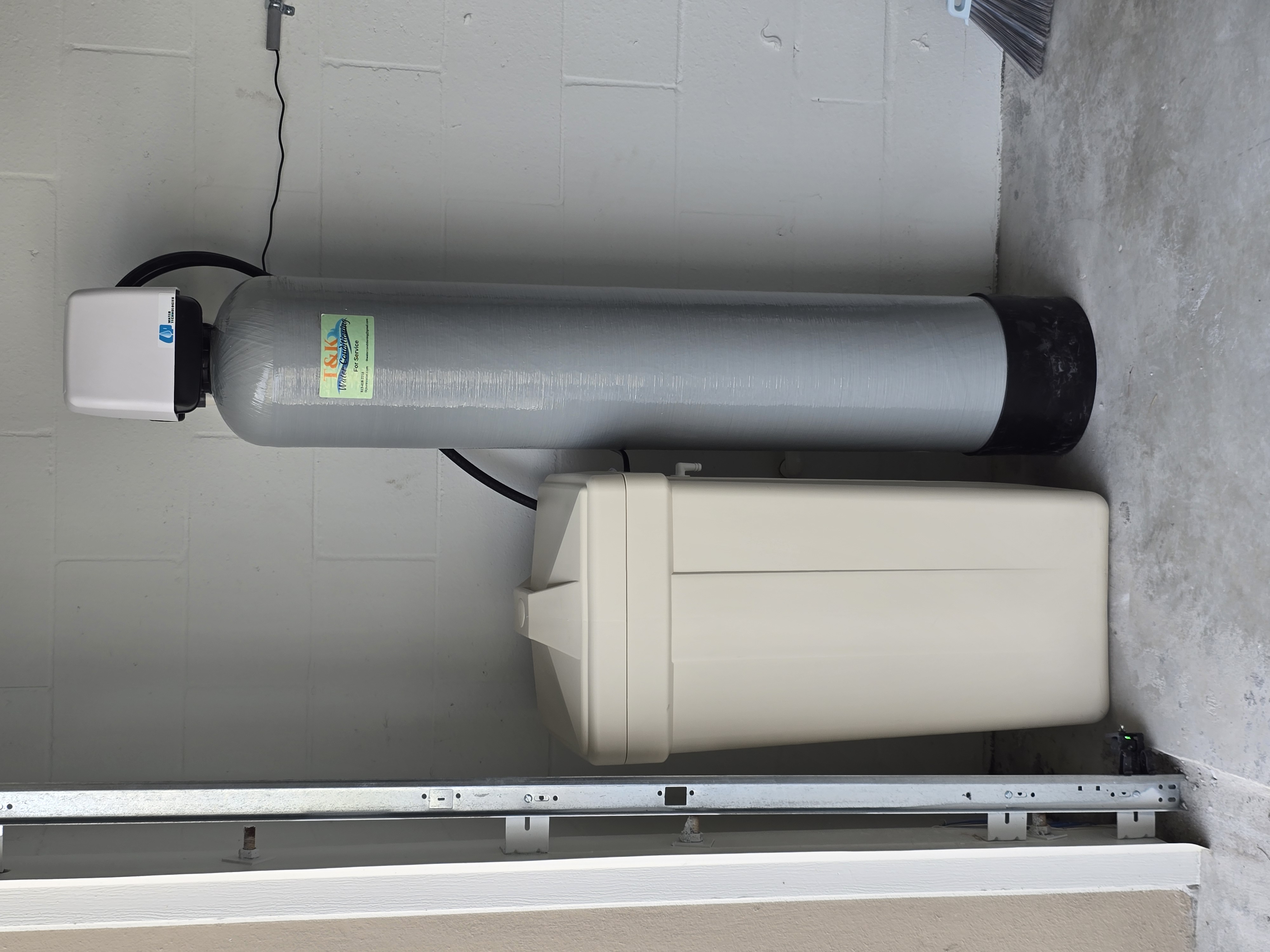 T&K Water Conditioning dual-tank whole-home system — softener and iron filter — in Tampa Bay garage